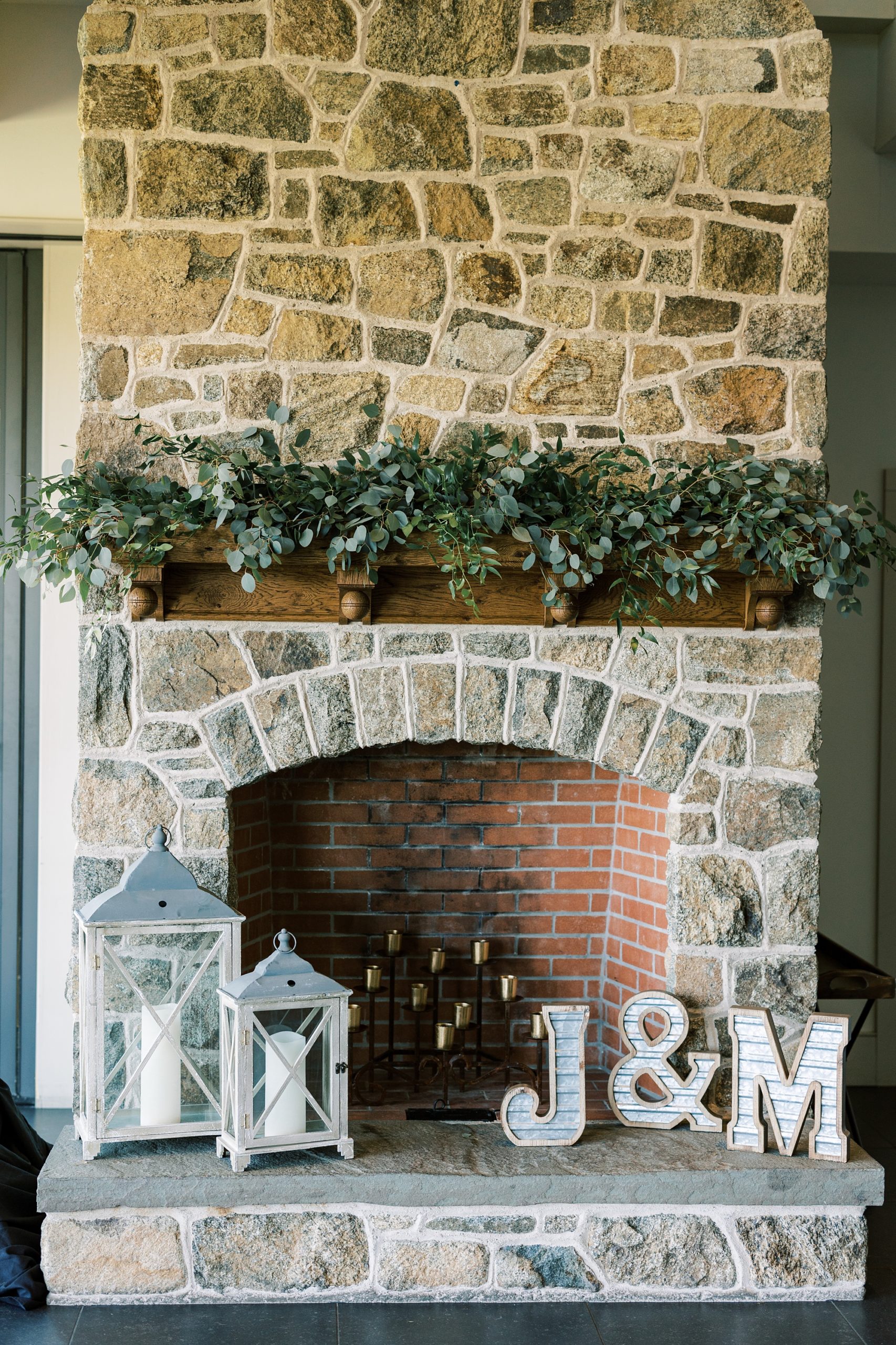 stone fireplace with custom letters and lanterns at French Creek Golf Club