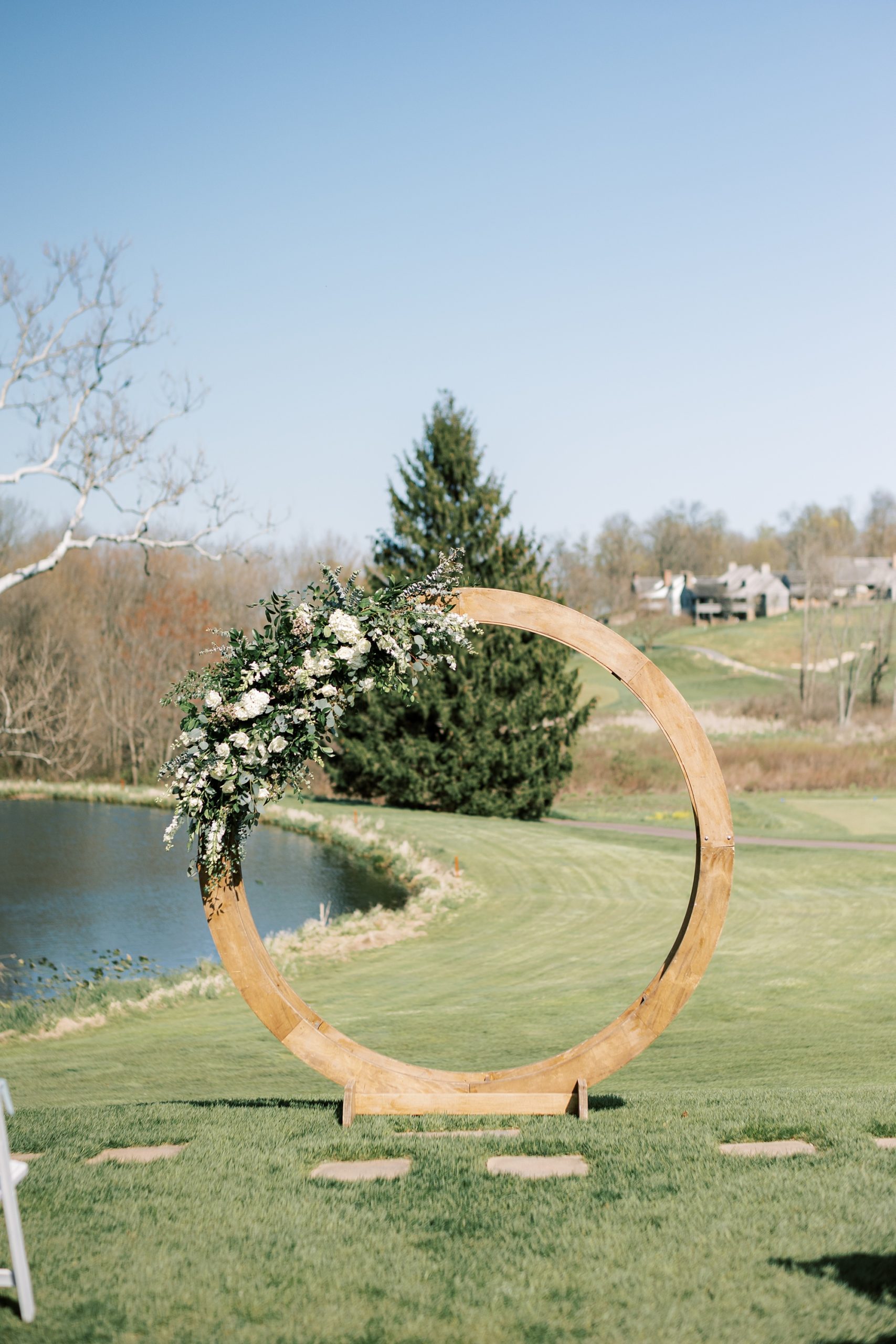wooden arbor with white flowers for outdoor spring wedding ceremony on the lawn of French Creek Golf Club