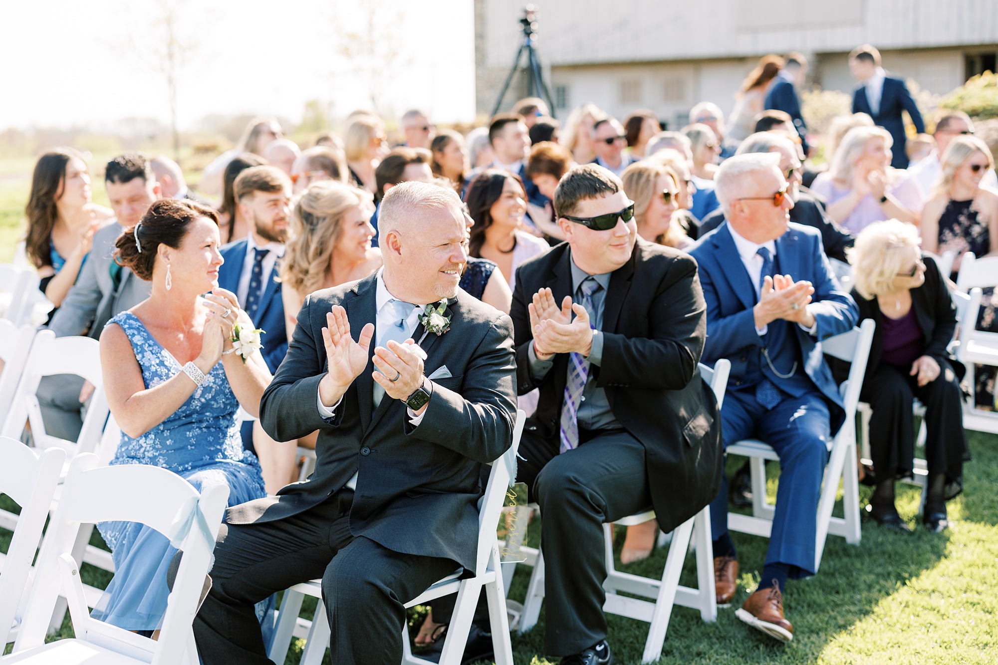 guests clap for groom to enter during outdoor wedding ceremony on the lawn of French Creek Golf Club
