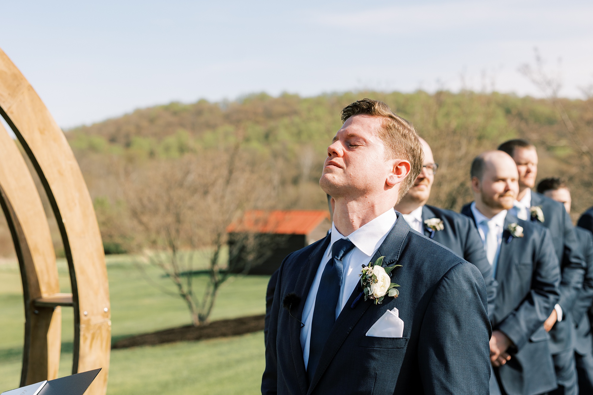 groom cries during outdoor wedding ceremony on the lawn of French Creek Golf Club