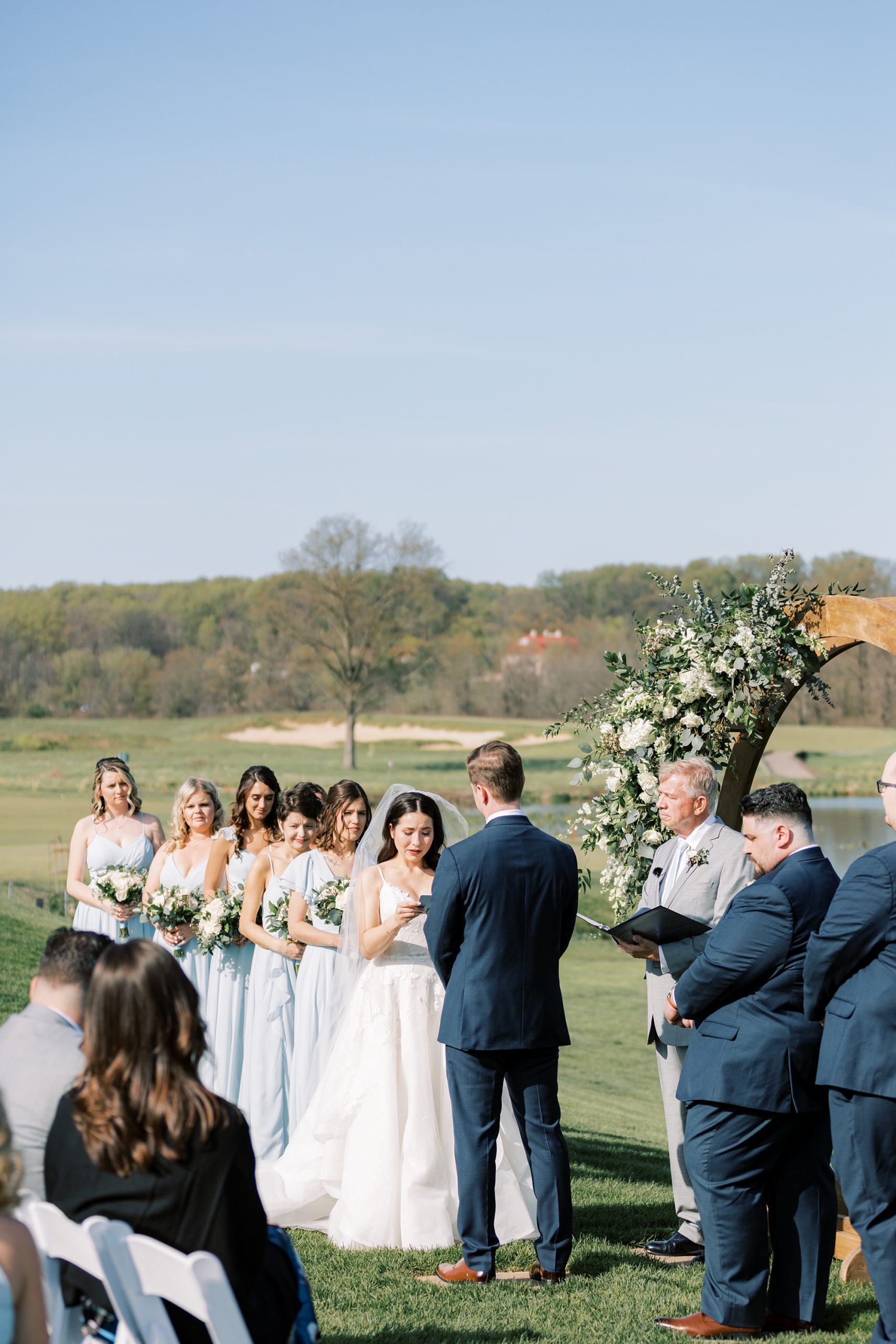 couple exchanges vows during outdoor wedding ceremony on the lawn of French Creek Golf Club