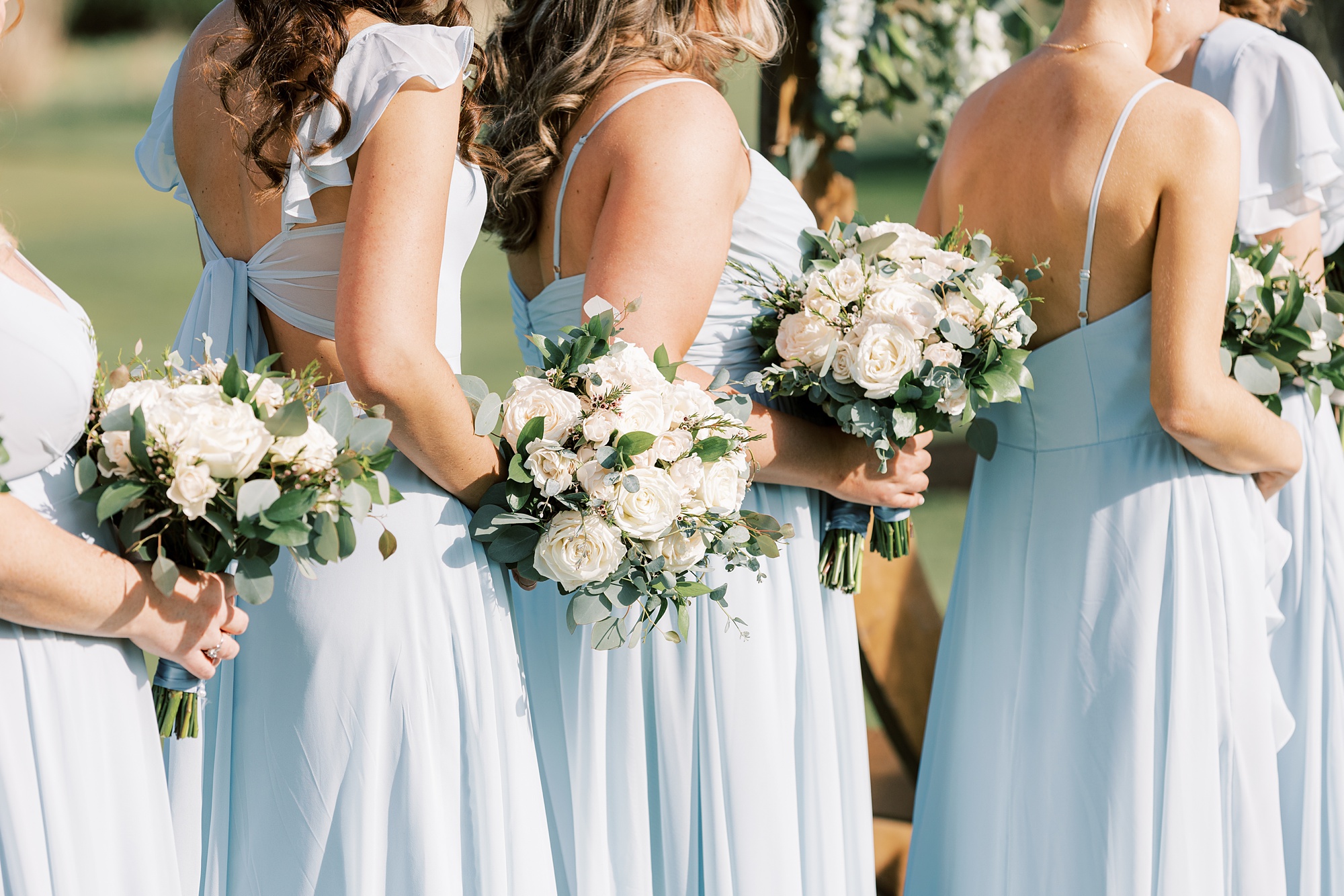 bridesmaids hold white bouquets during outdoor wedding ceremony on the lawn of French Creek Golf Club