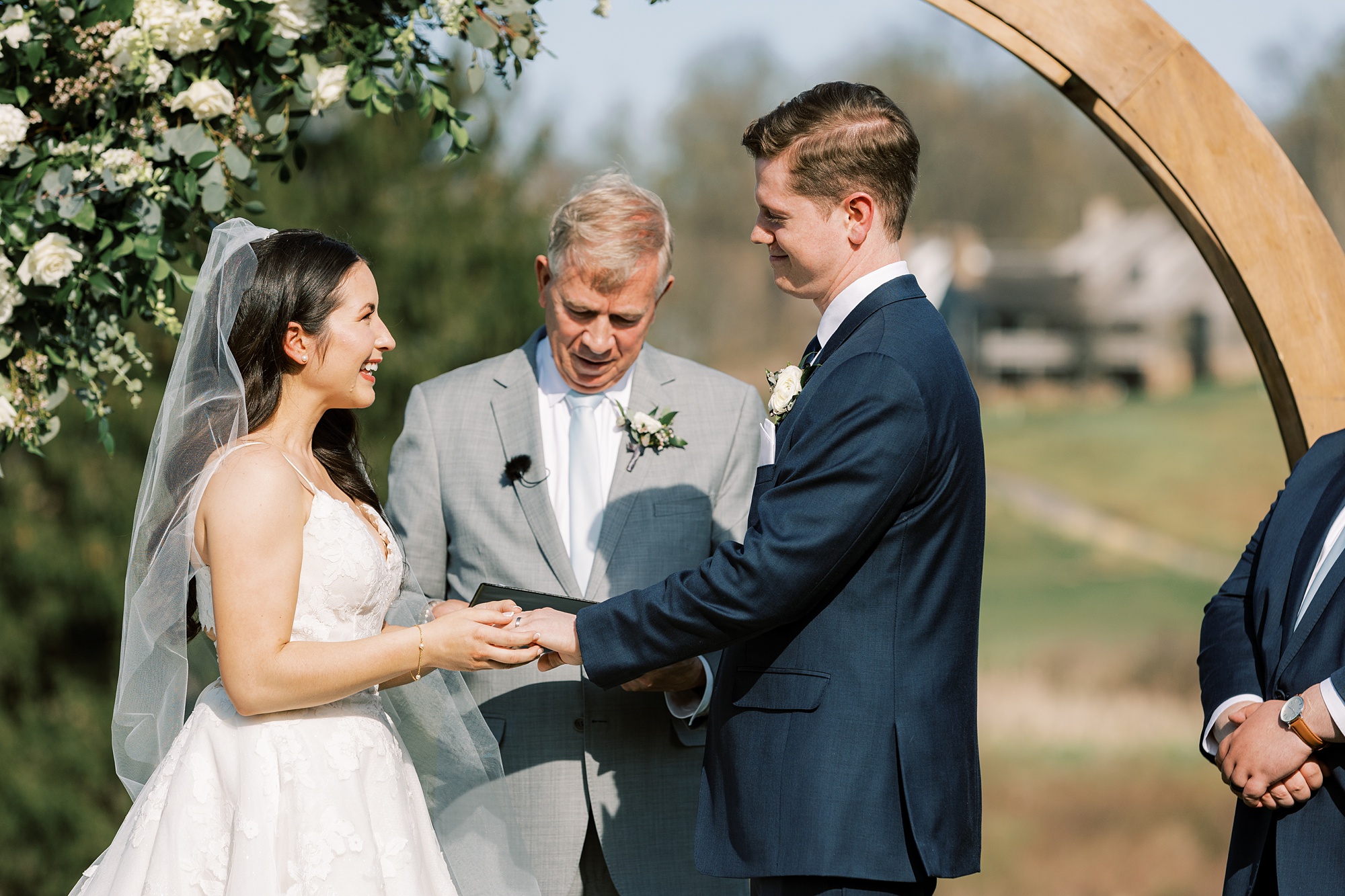 couple exchanges vows during outdoor wedding ceremony on the lawn of French Creek Golf Club
