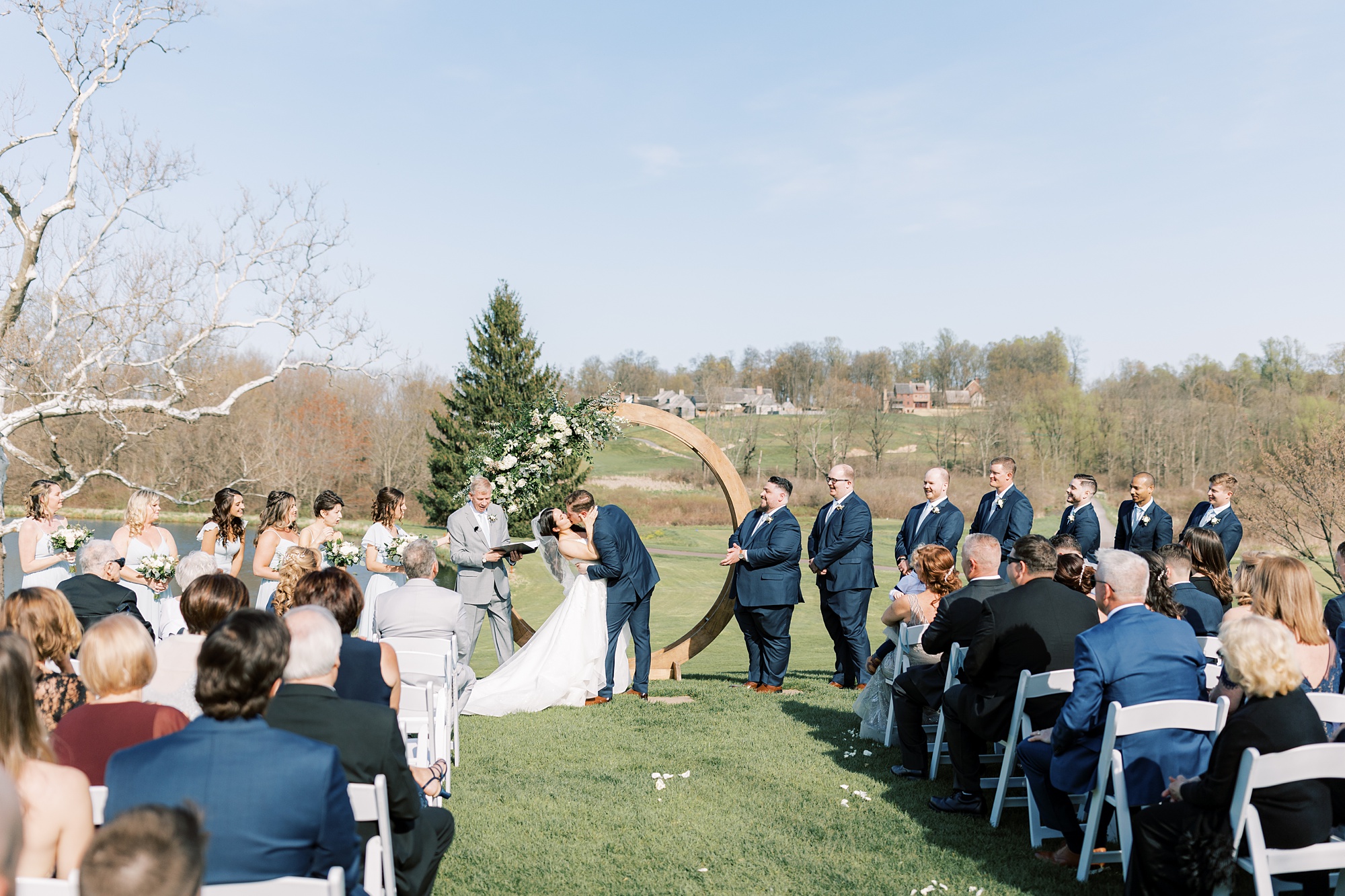 bride and groom kiss during outdoor wedding ceremony on the lawn of French Creek Golf Club