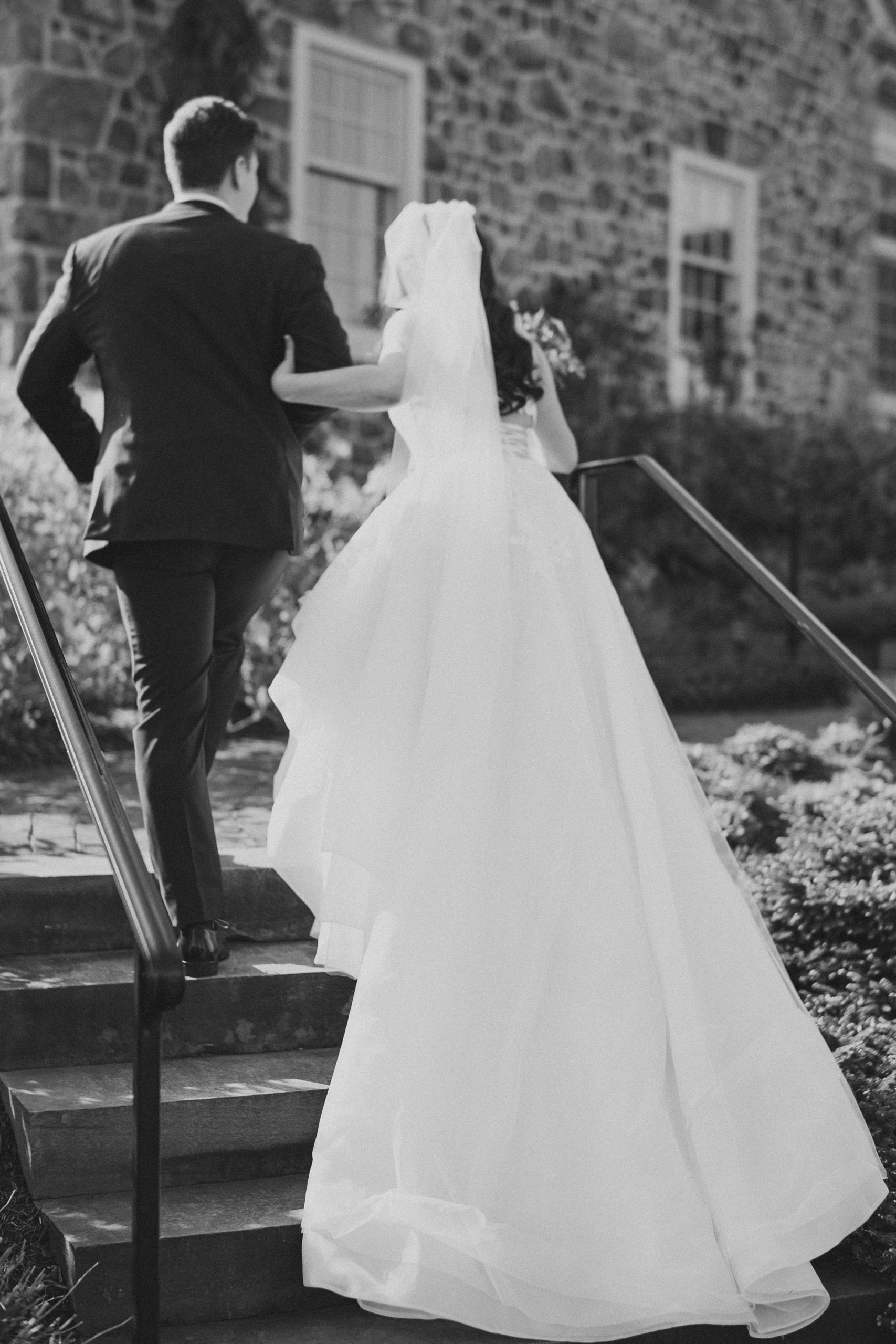 groom helps bride up steps at French Creek Golf Club 