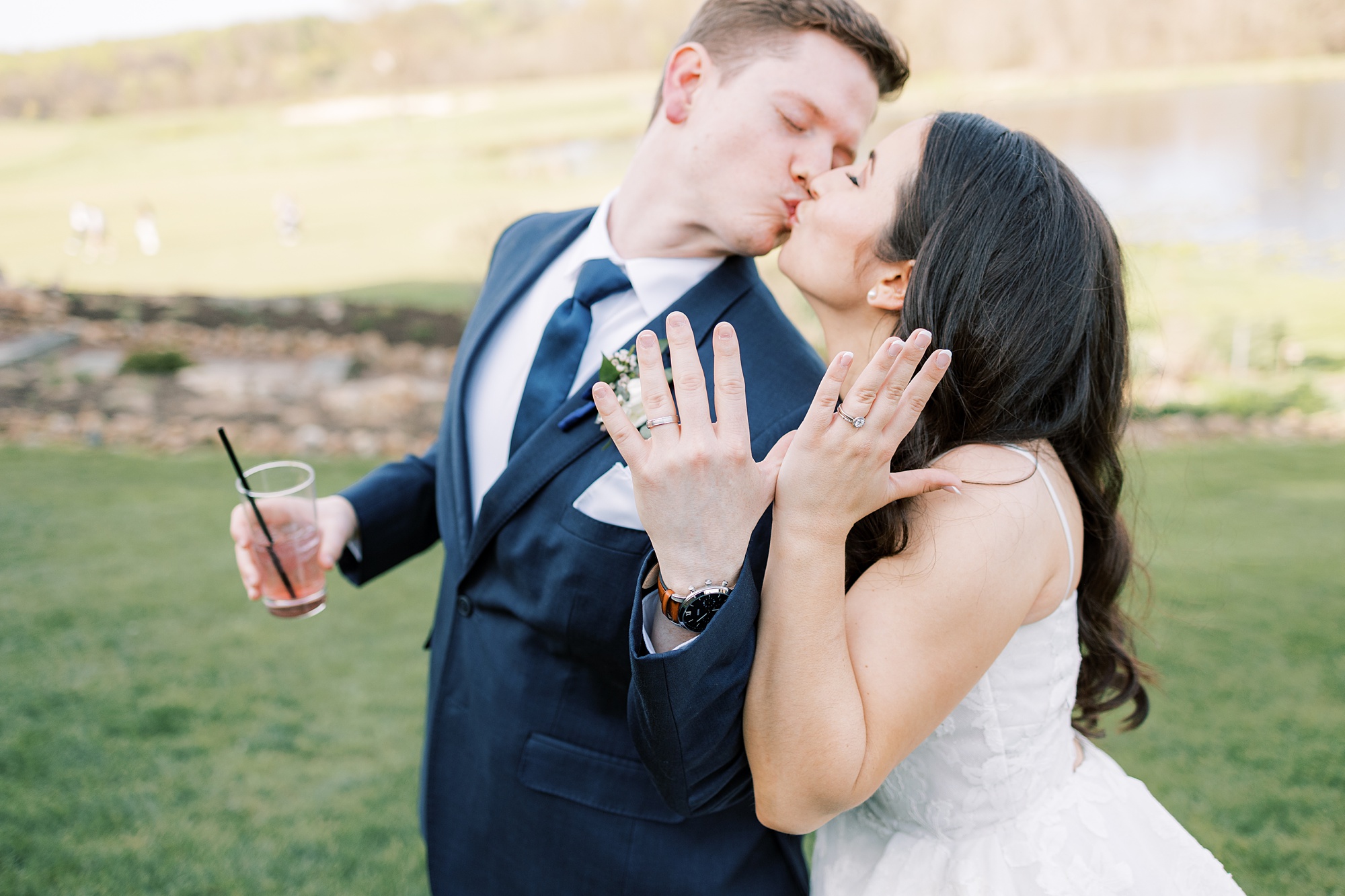 bride and groom kiss showing off rings at French Creek Golf Club 