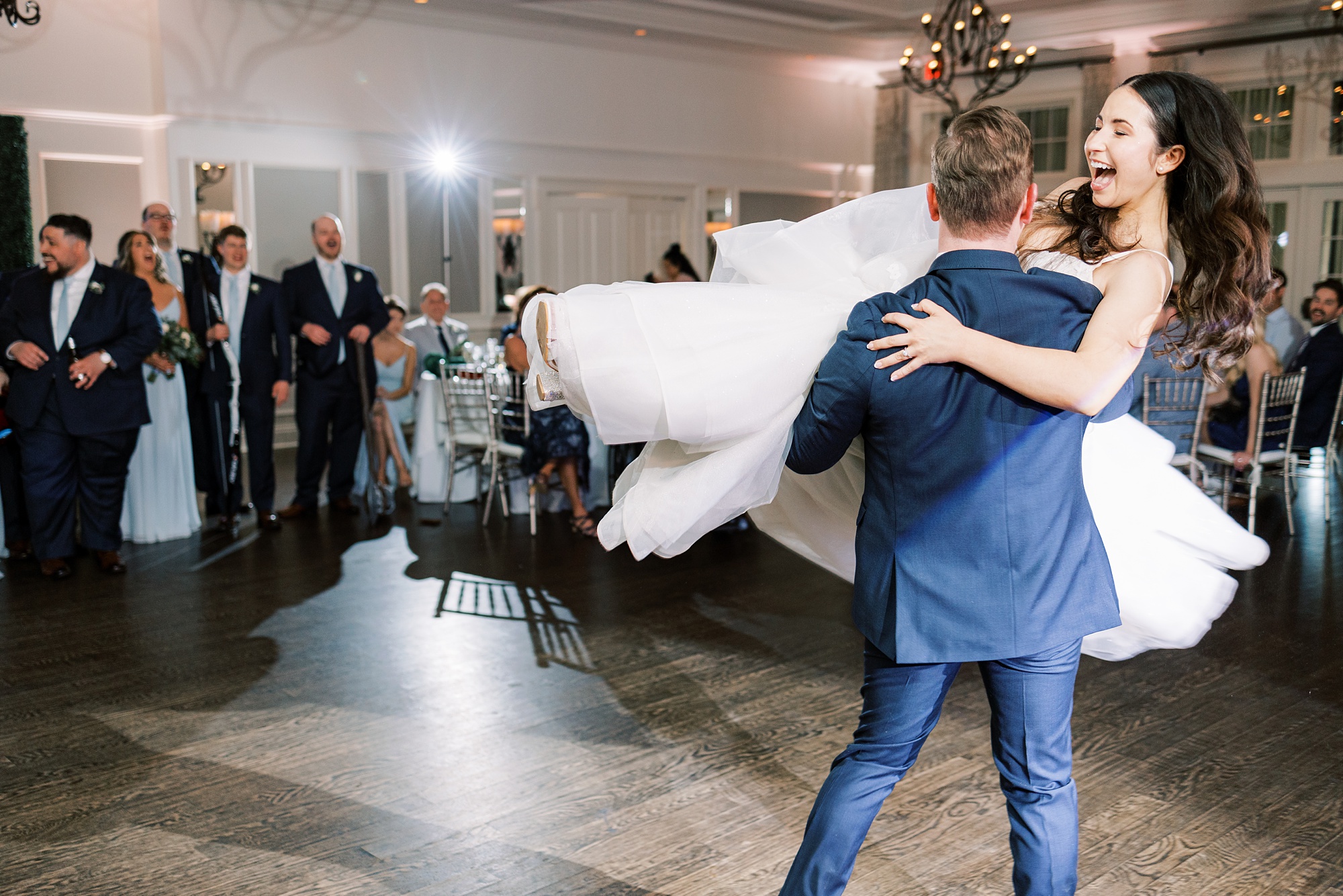 groom lifts bride twirling her during Chester County PA wedding reception