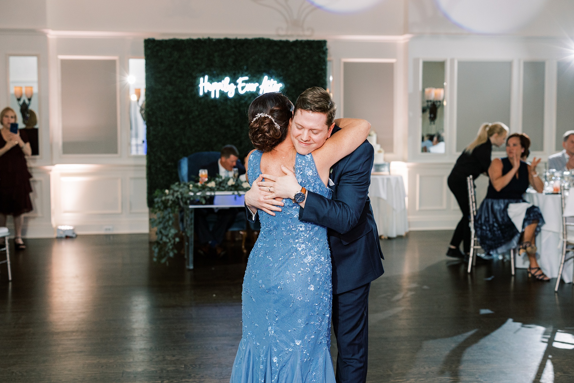 groom hugs mom in blue dress during Chester County PA wedding reception