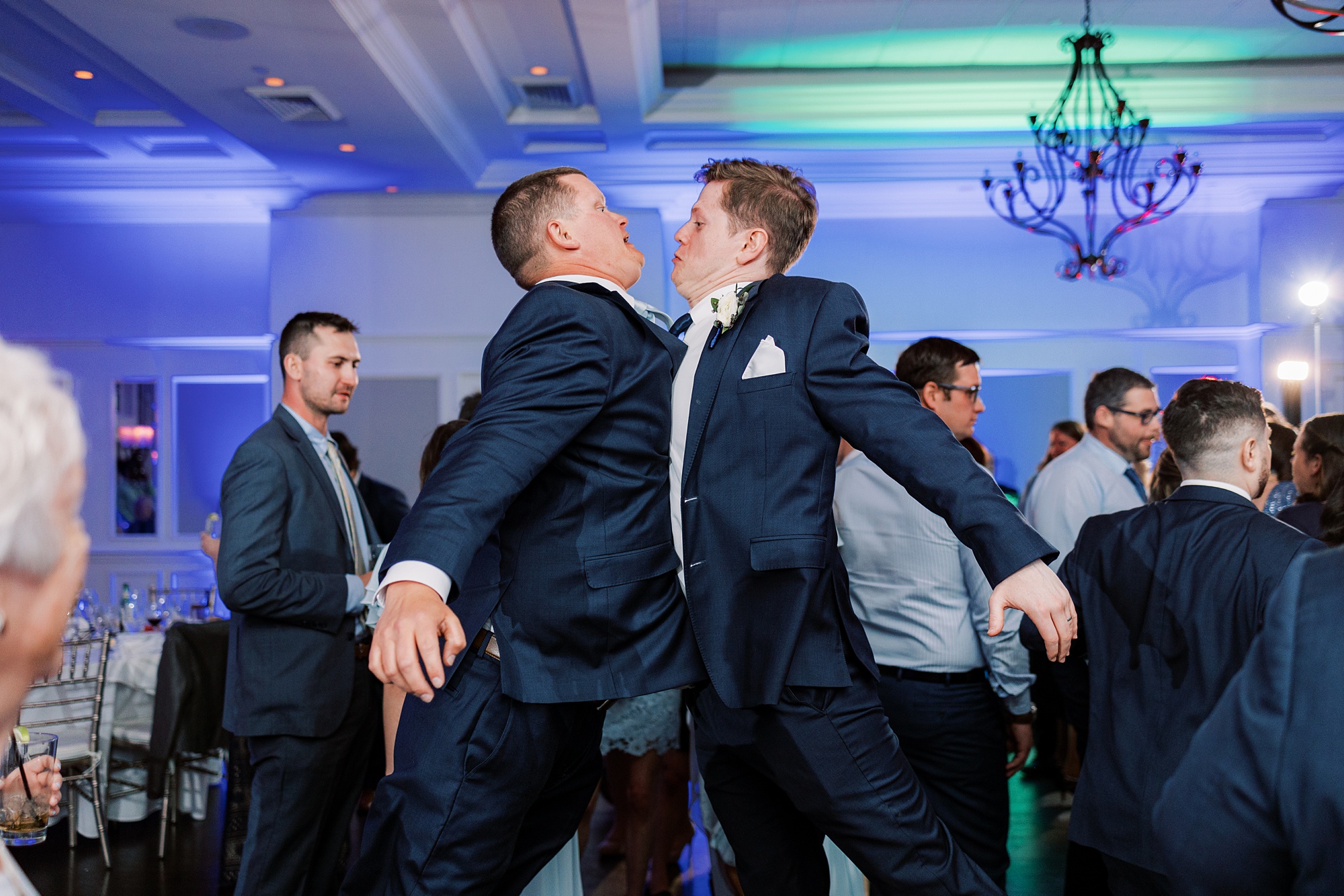 groom chest bumps with groomsman during Chester County PA wedding reception