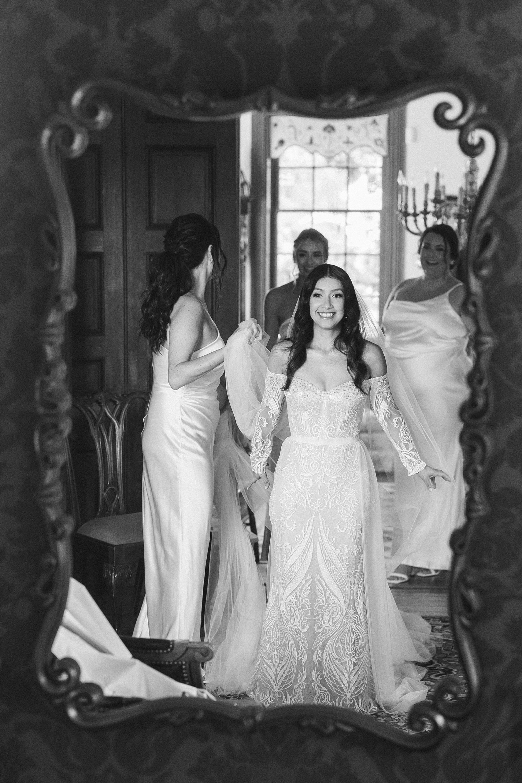 bridesmaids help bride with veil before ceremony at The Cypress House