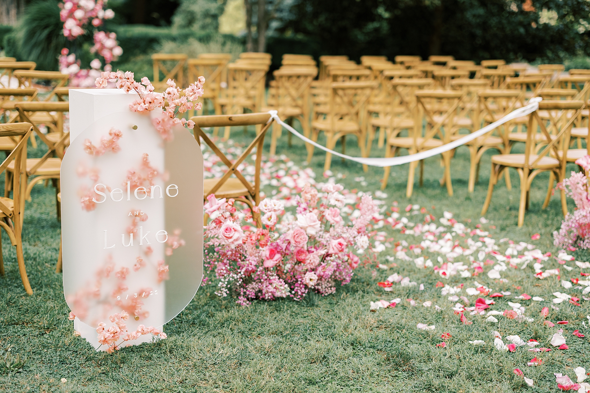 ceremony site with pink florals down aisle 