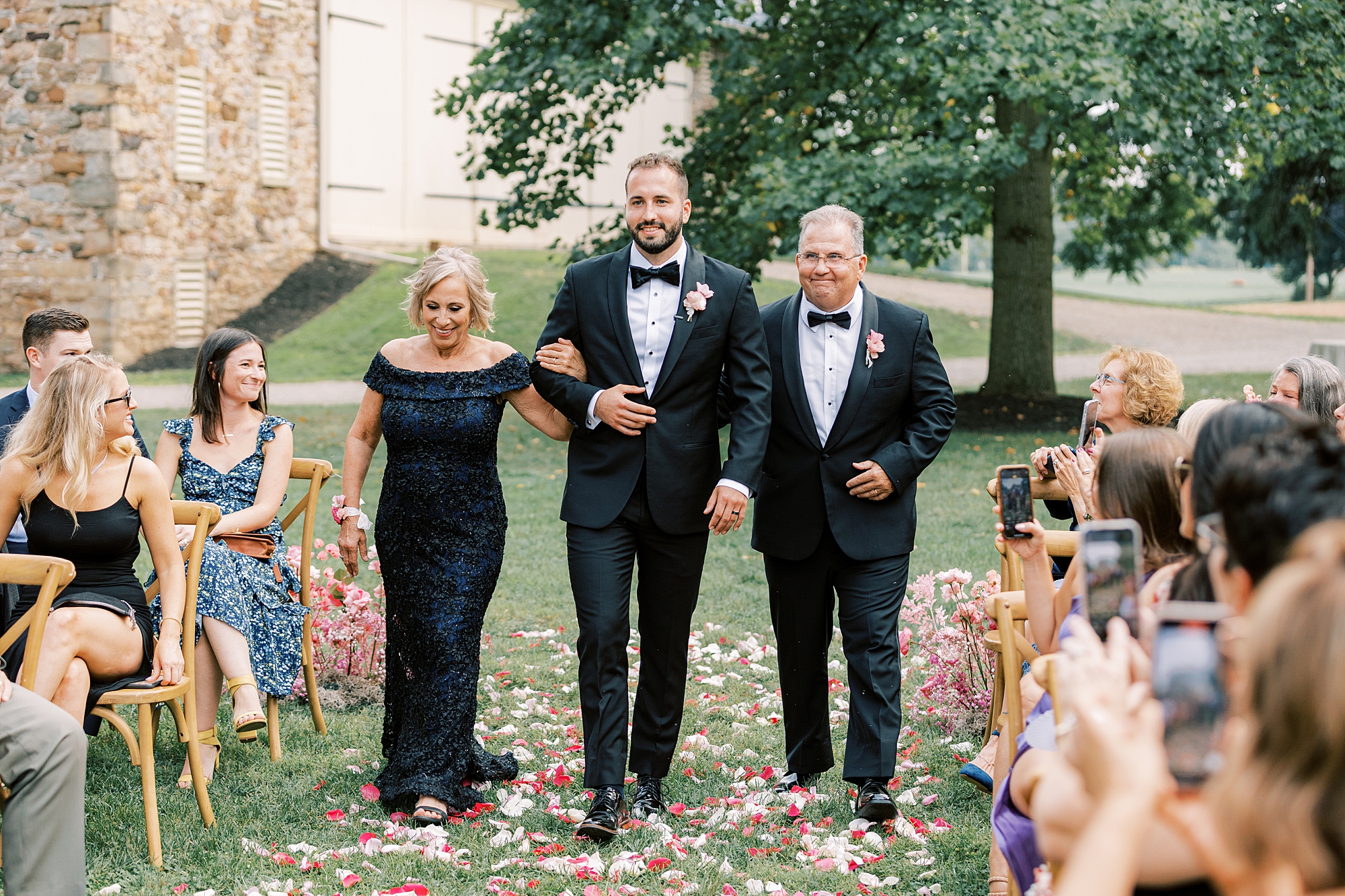 groom walks down the aisle with father and mother at The Cypress House