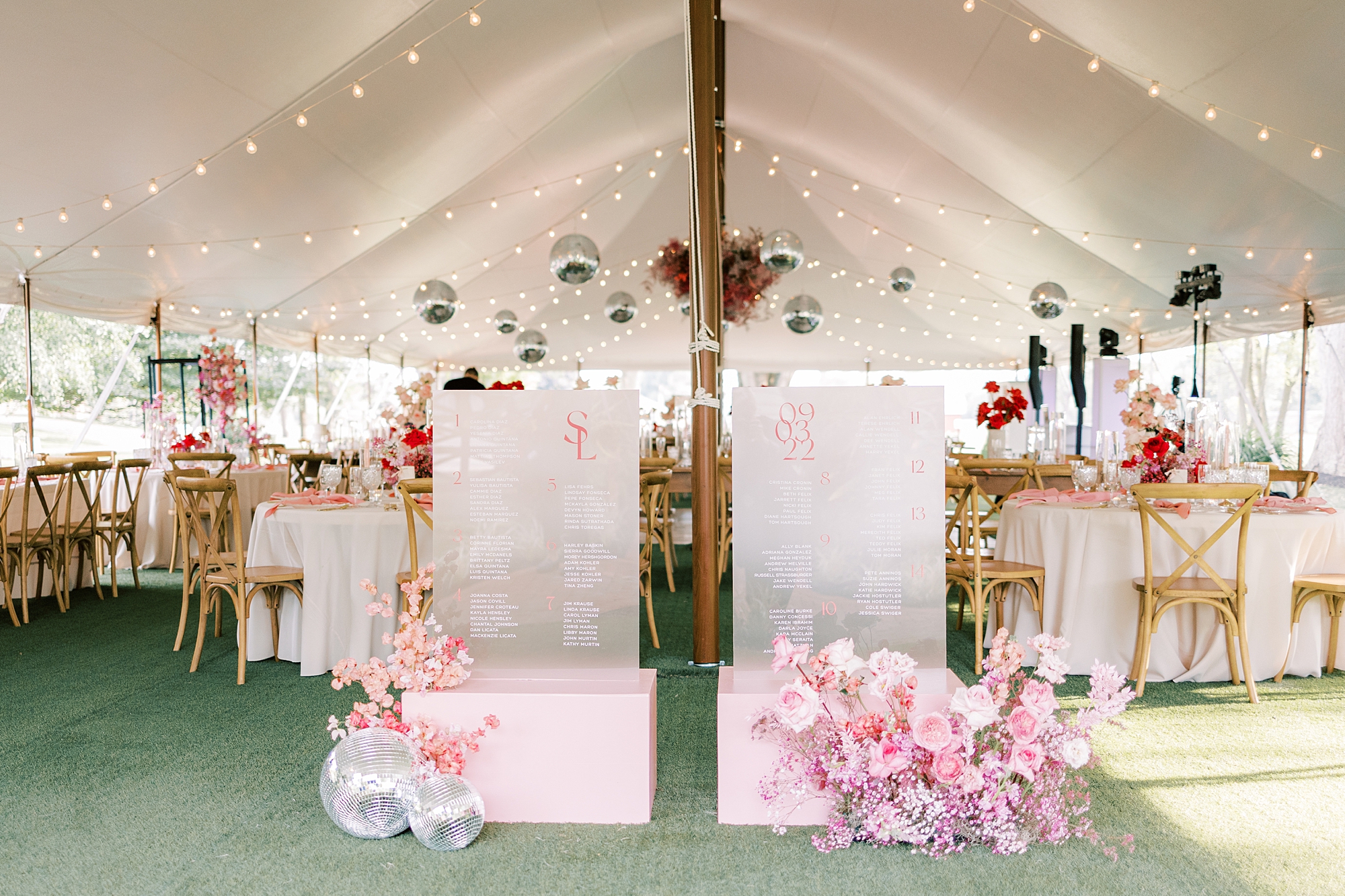 pink seating charts on acrylic signs under tent 