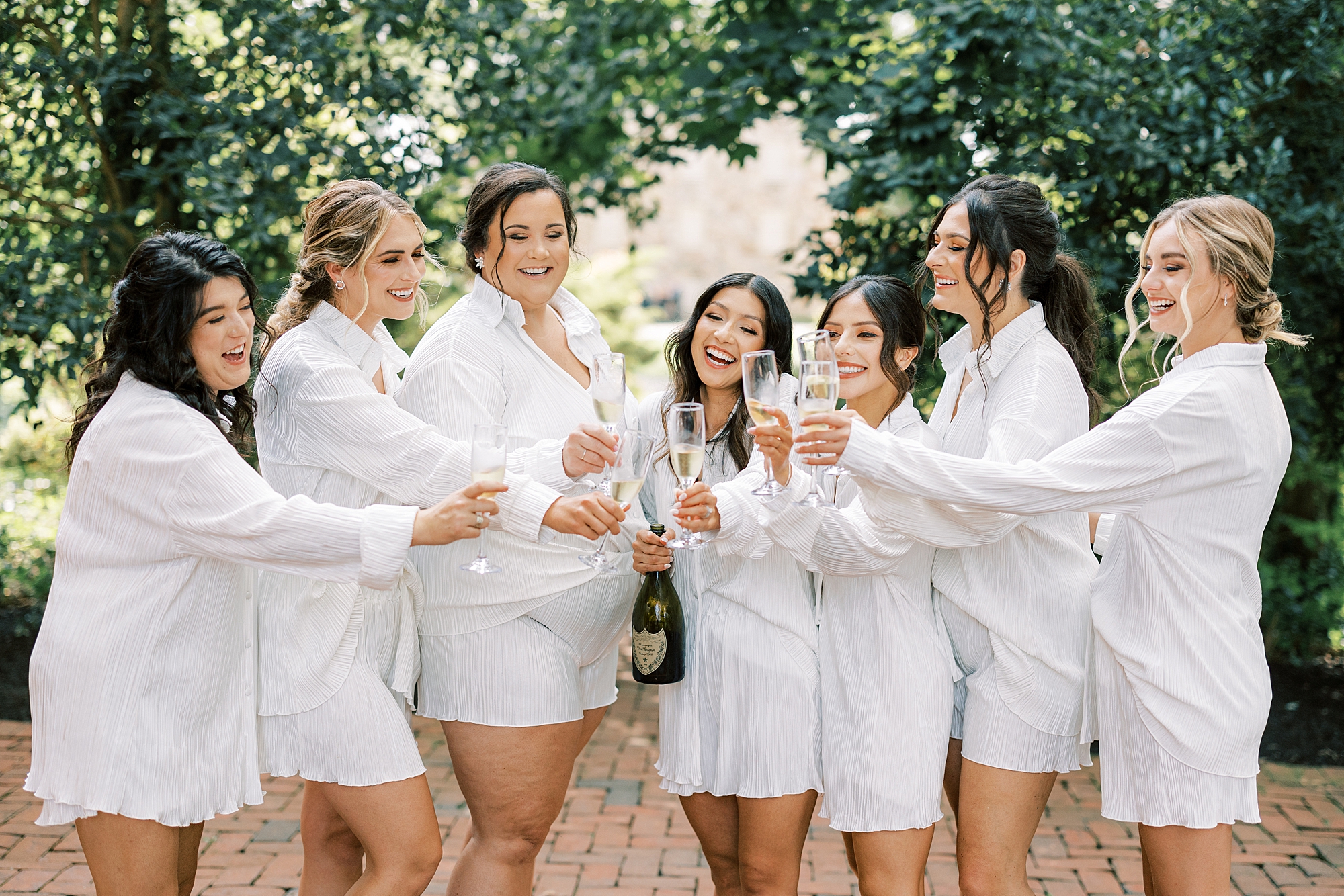 bride and bridesmaids toast with champagne on wedding morning 