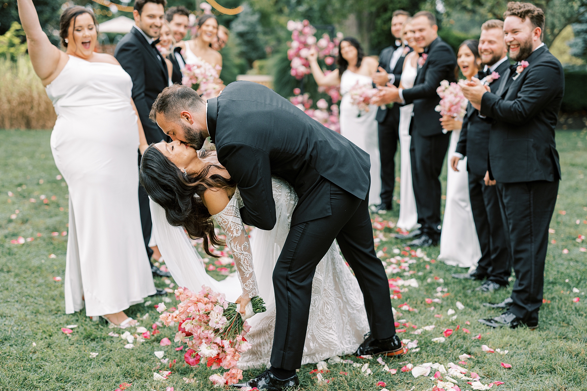 groom dips bride in aisle kissing her after wedding ceremony 