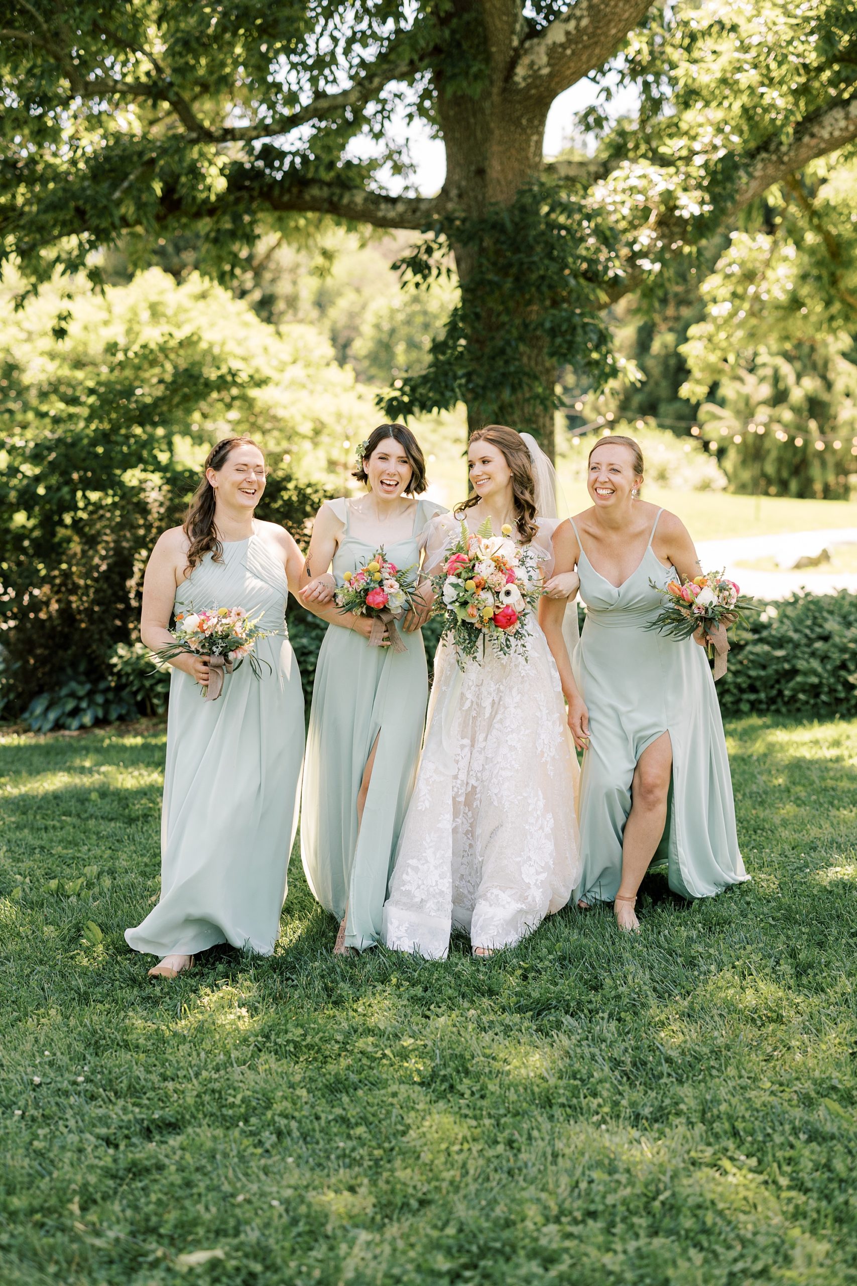 bride walks with bridesmaids in mint green gowns