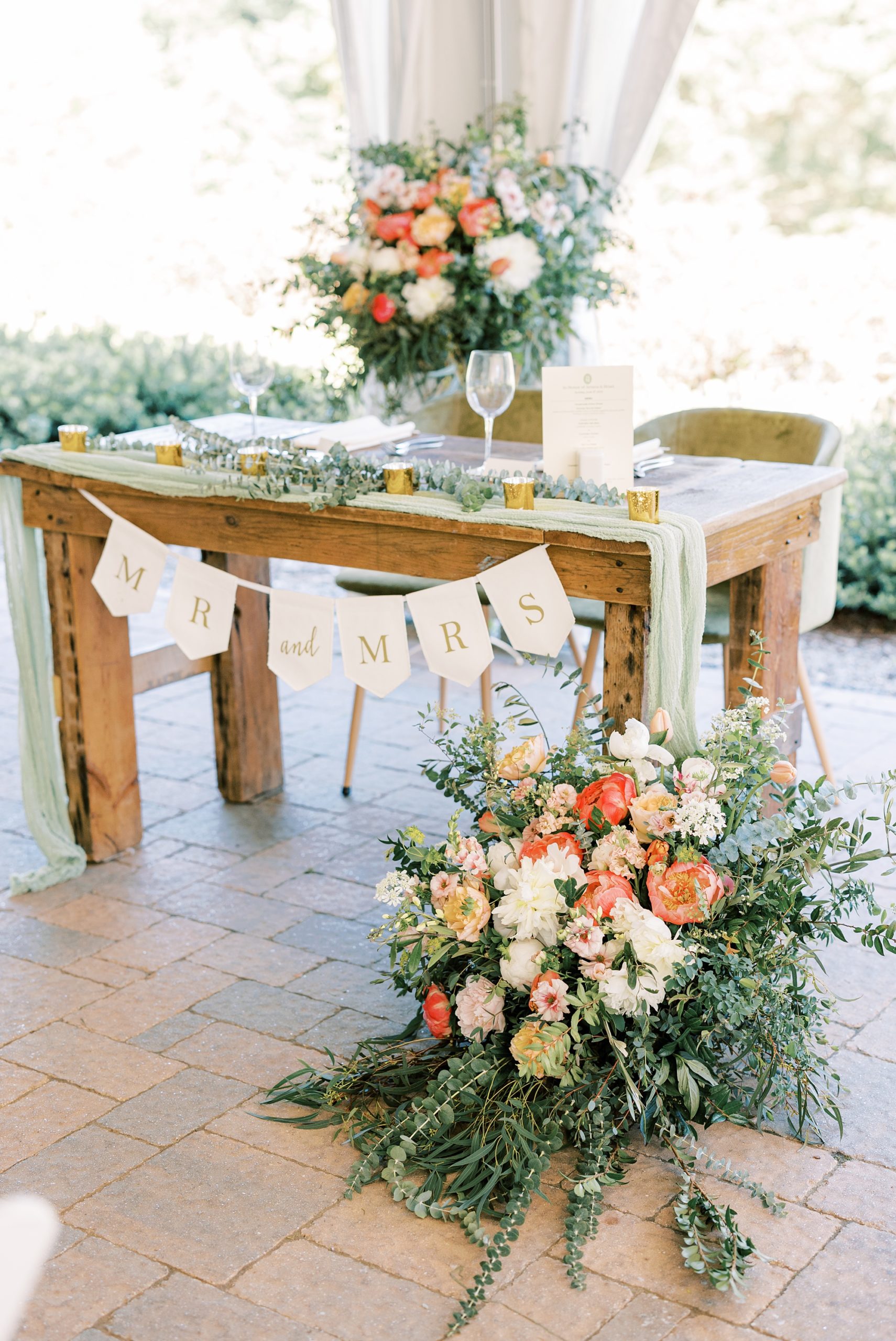 sweetheart table with peach and white floral displays 