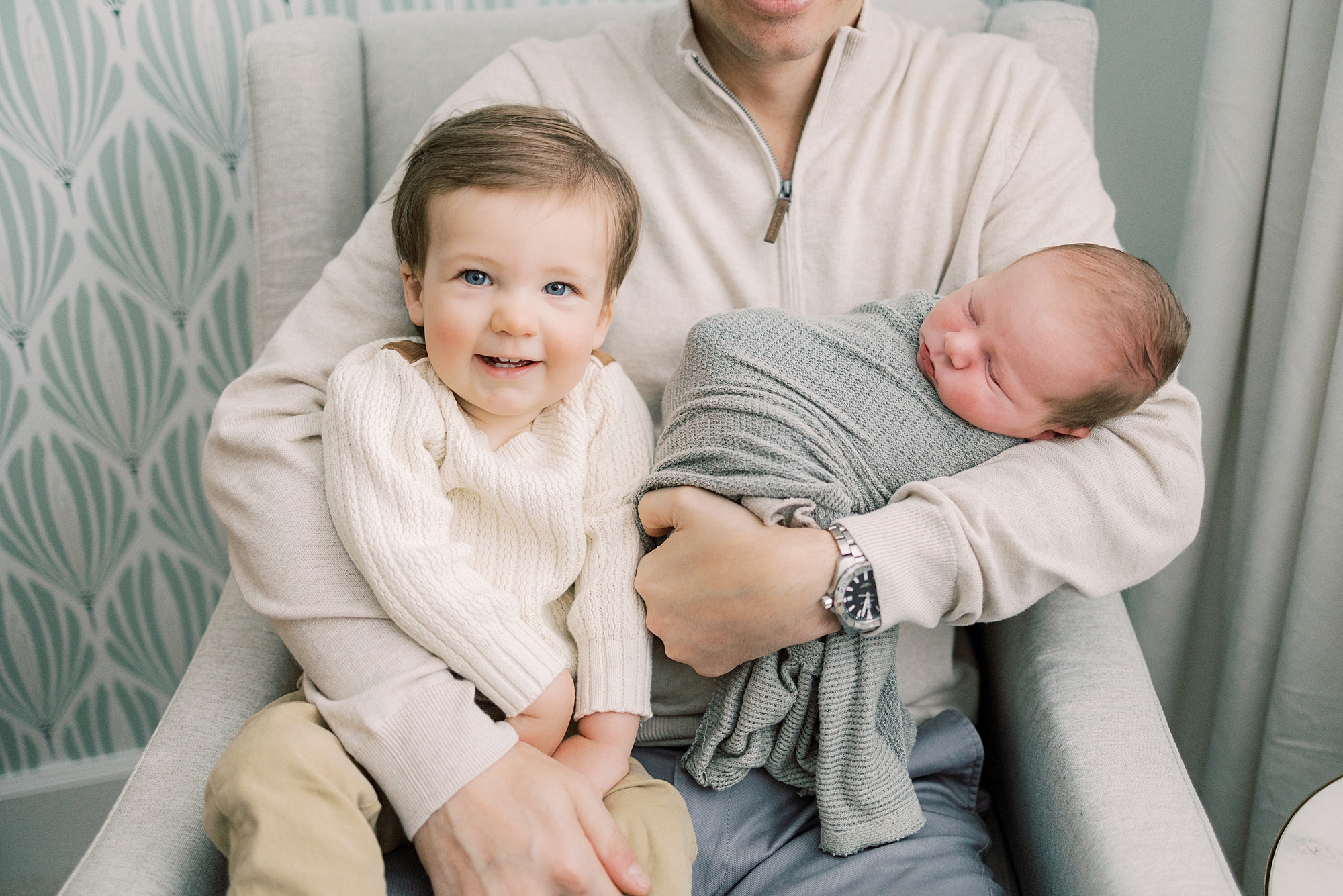 dad holds toddler son and new baby boy in his arms during PA newborn session