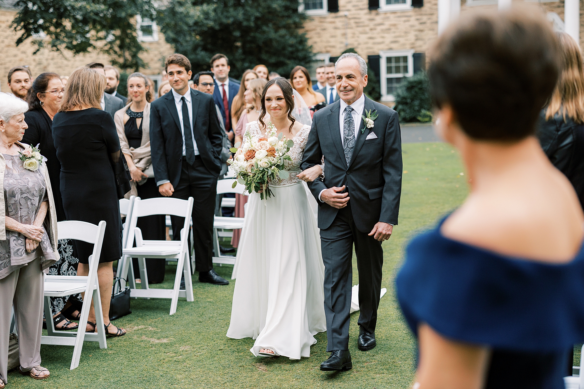 bride walks down the aisle with dad on lawn at Huntingdon Valley Country Club