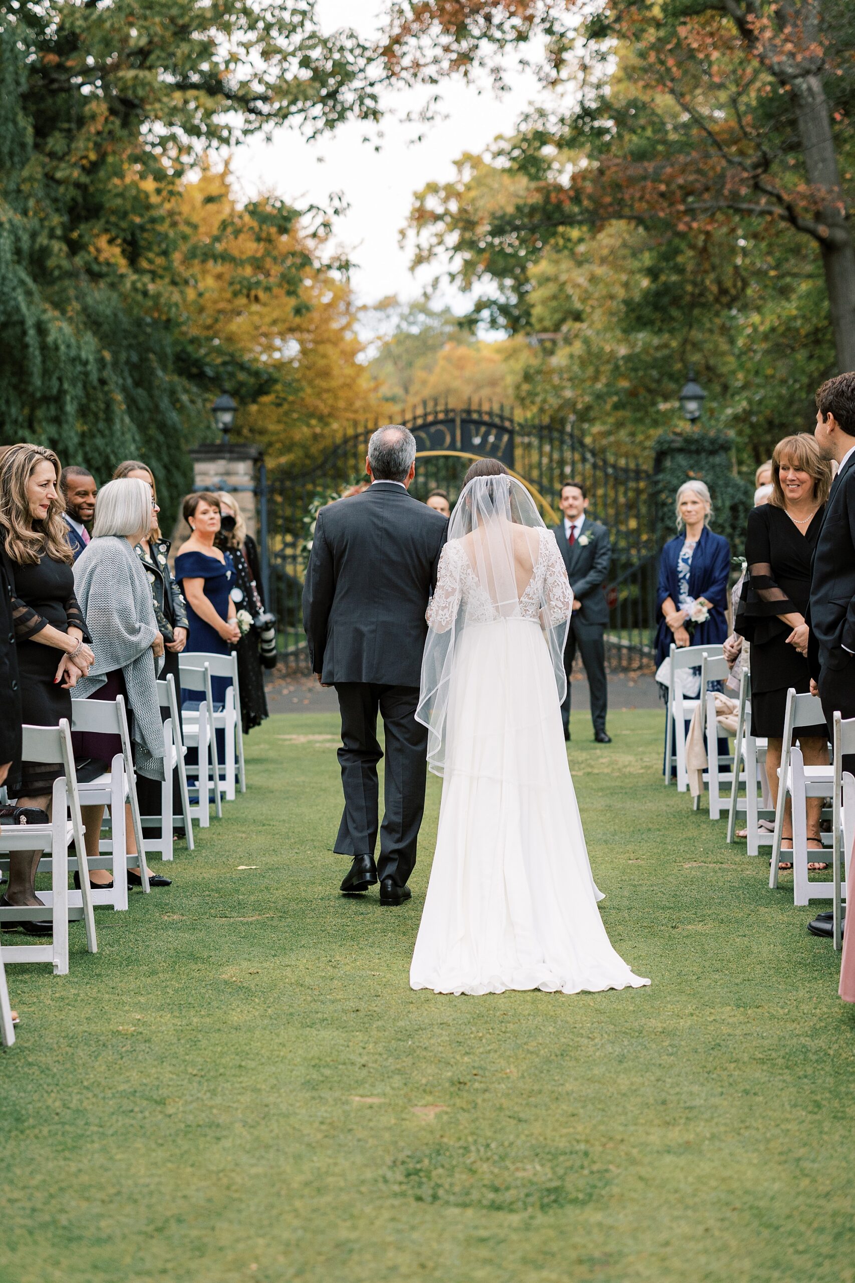 bride walks down aisle with father for fall wedding ceremony