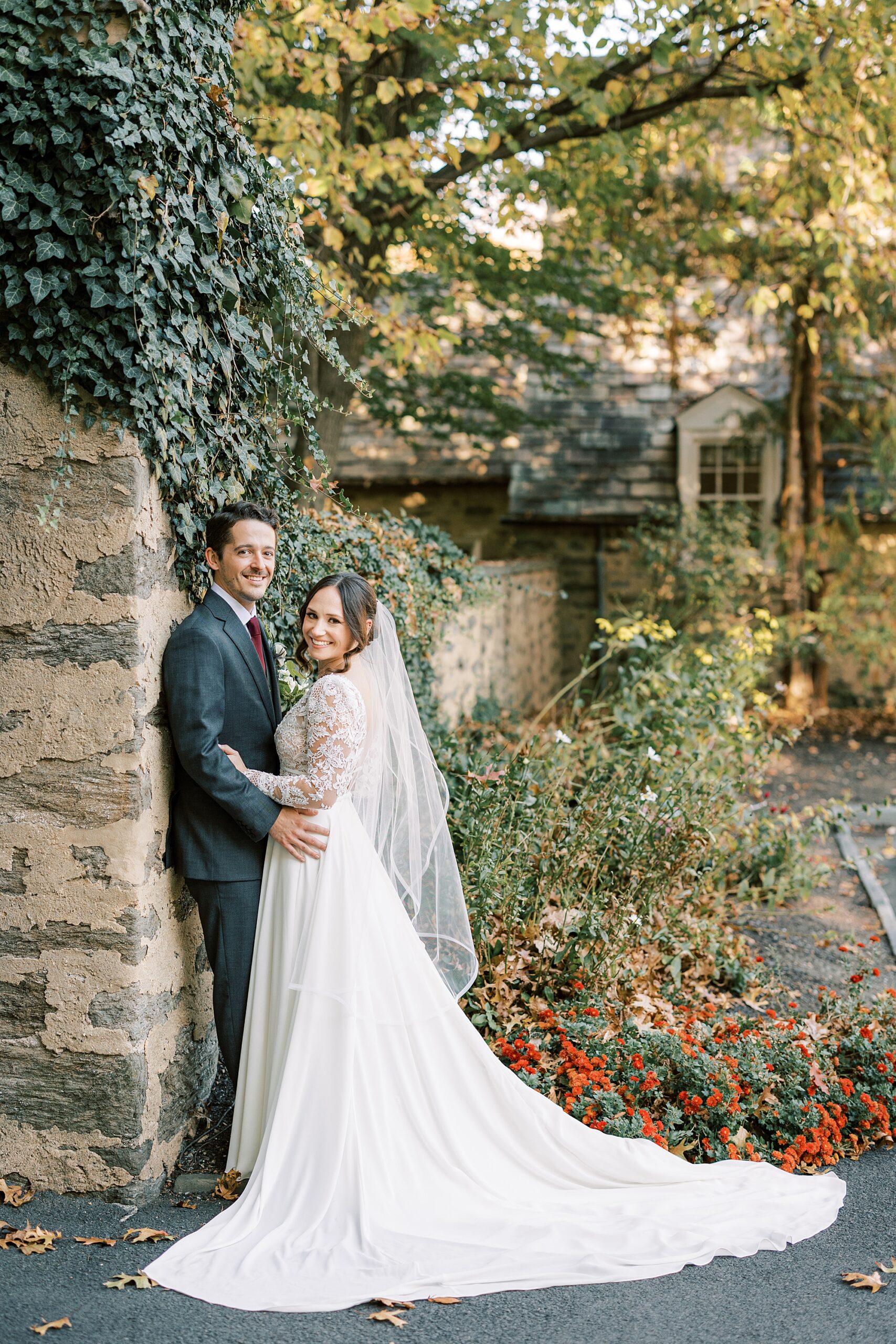 bride and from lean against stone wall at Huntingdon Valley Country Club