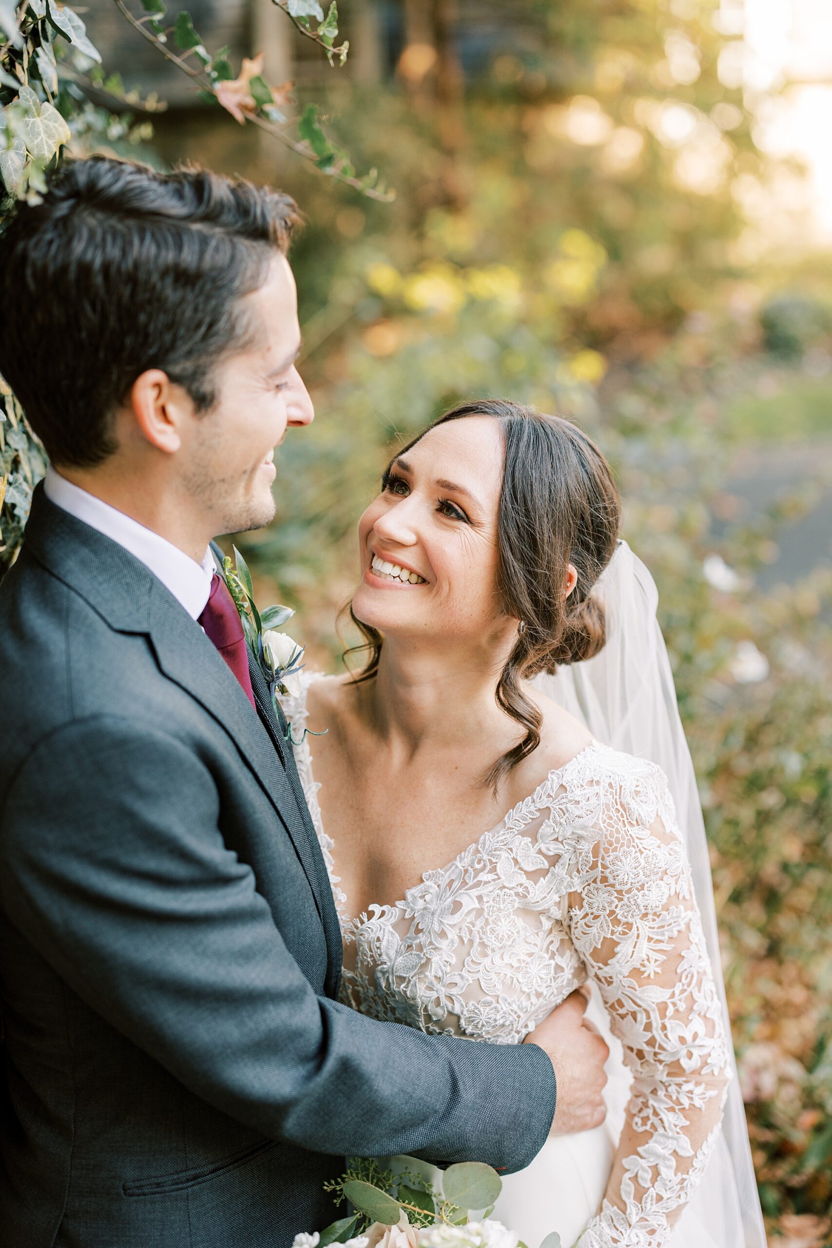 bride grins up at groom during fall wedding portraits at Huntingdon Valley Country Club