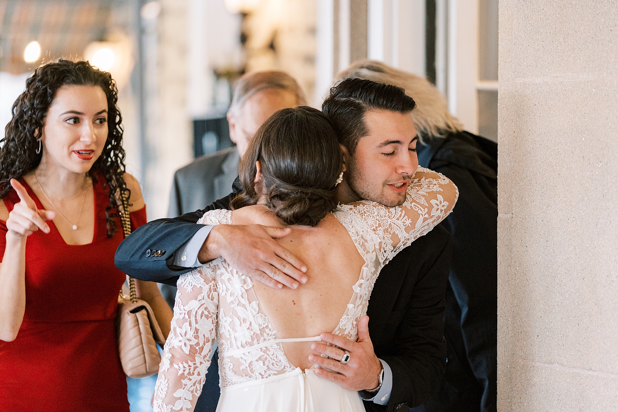 bride hugs guest during cocktail hour