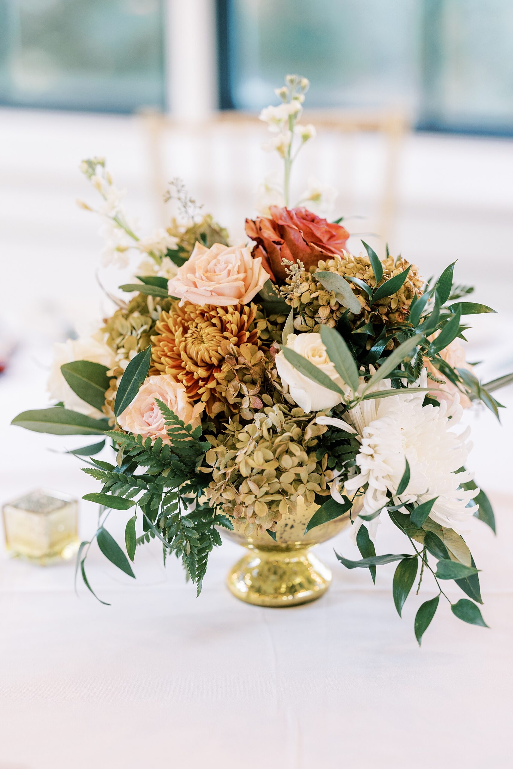 floral centerpiece rests in gold vase at Huntingdon Valley Country Club