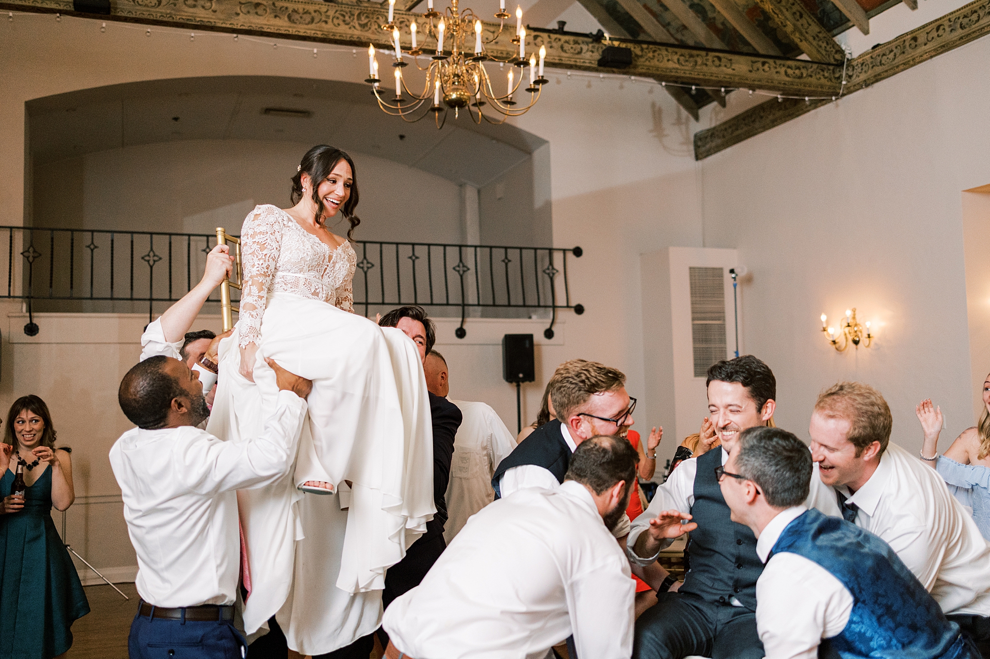 groomsmen lift bride up in chair during PA wedding reception