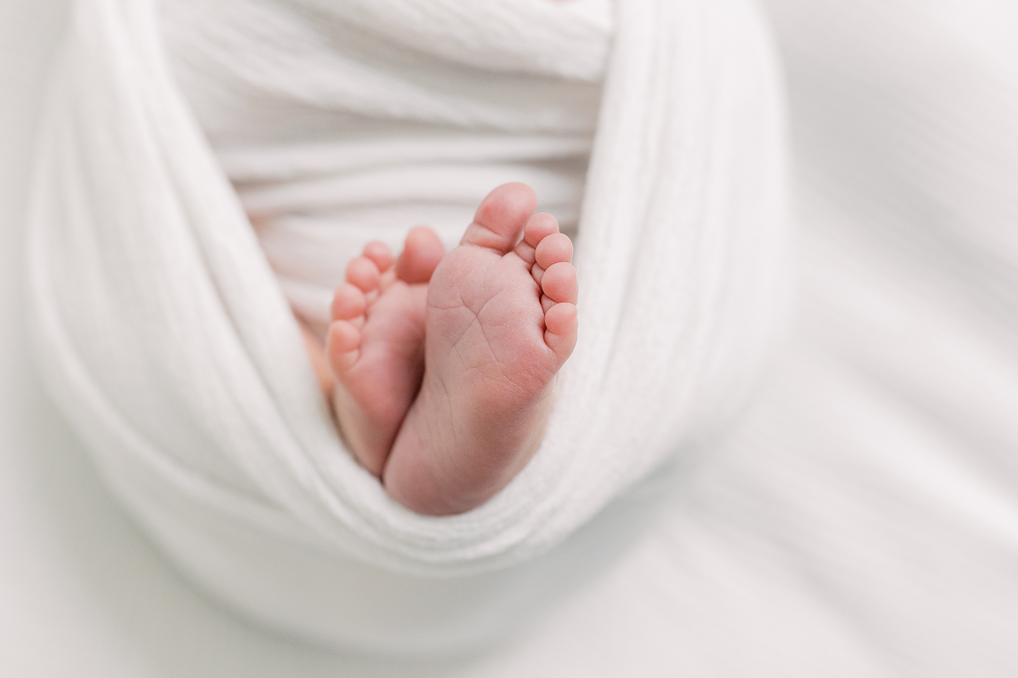 baby's feet in bottom of white wrap 