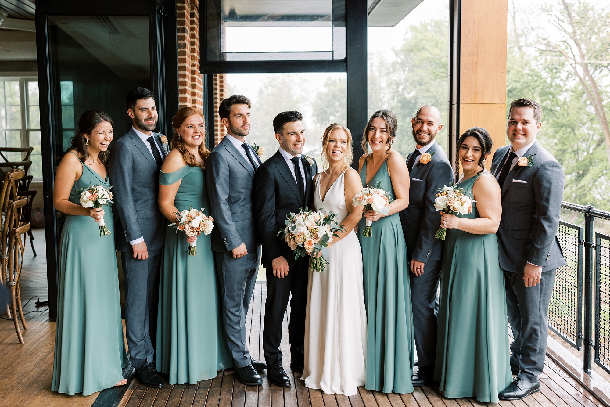 bride and groom stand with wedding party on patio