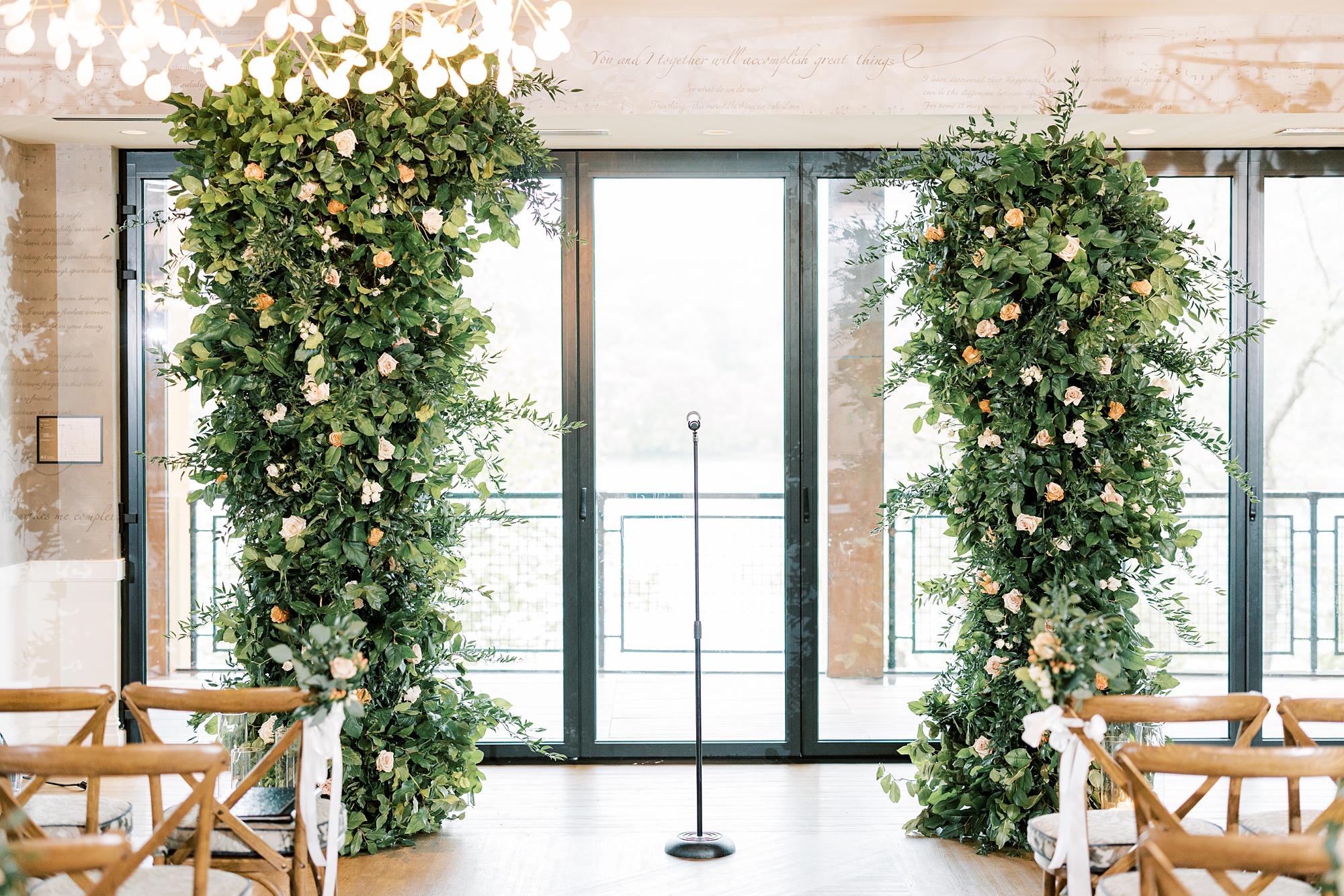 ceremony site with tall floral displays inside the River House at Odette's
