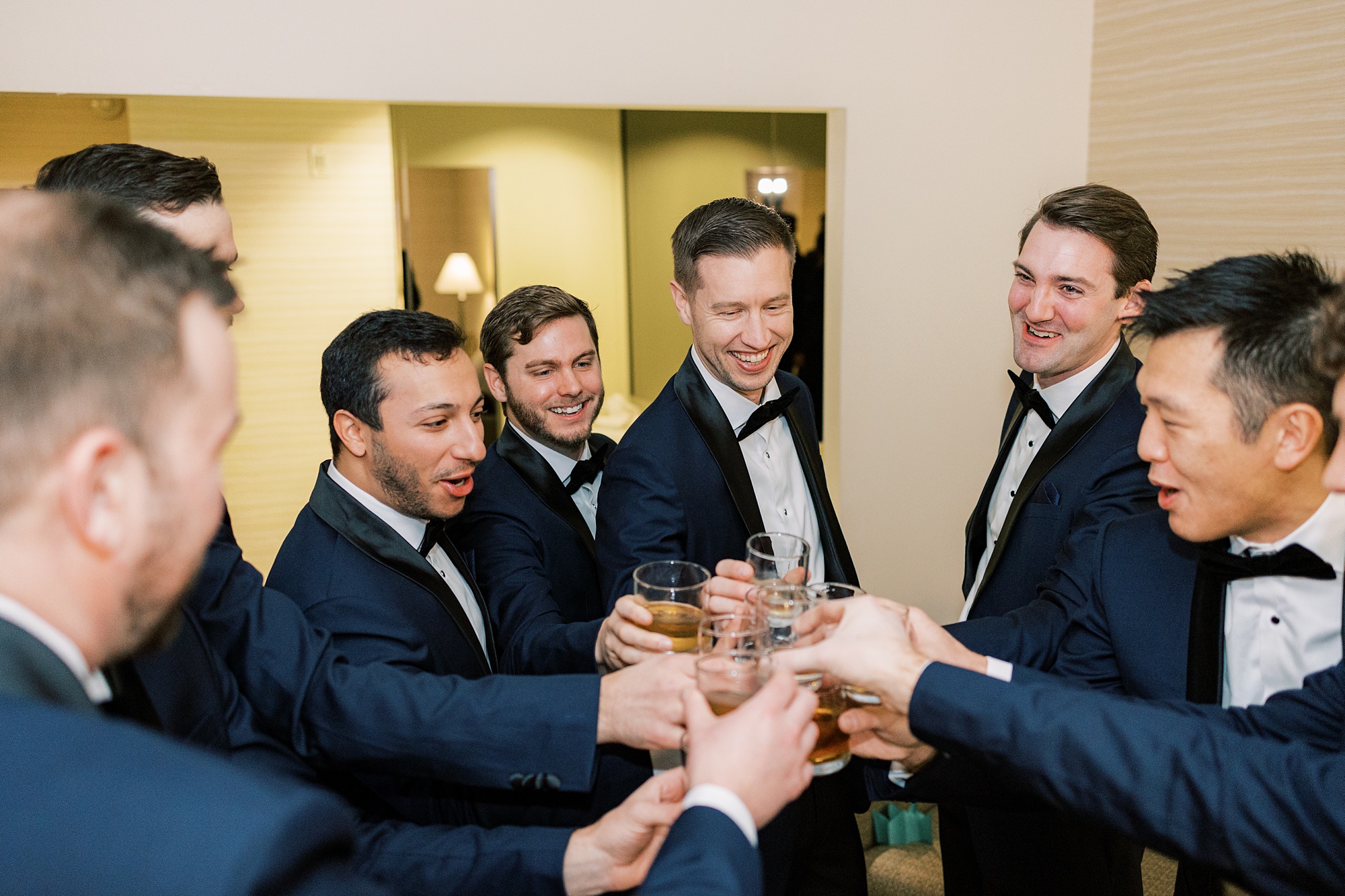 groom toasts with groomsmen in blue jackets 
