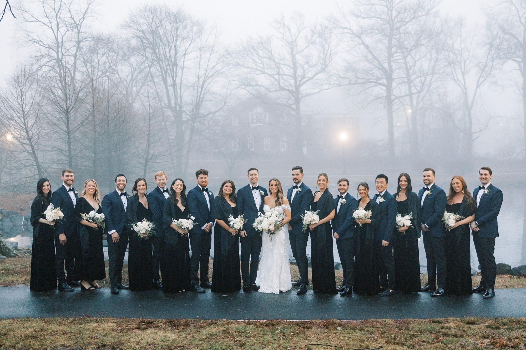 bride and groom pose with wedding party in blue and black in New Jersey park