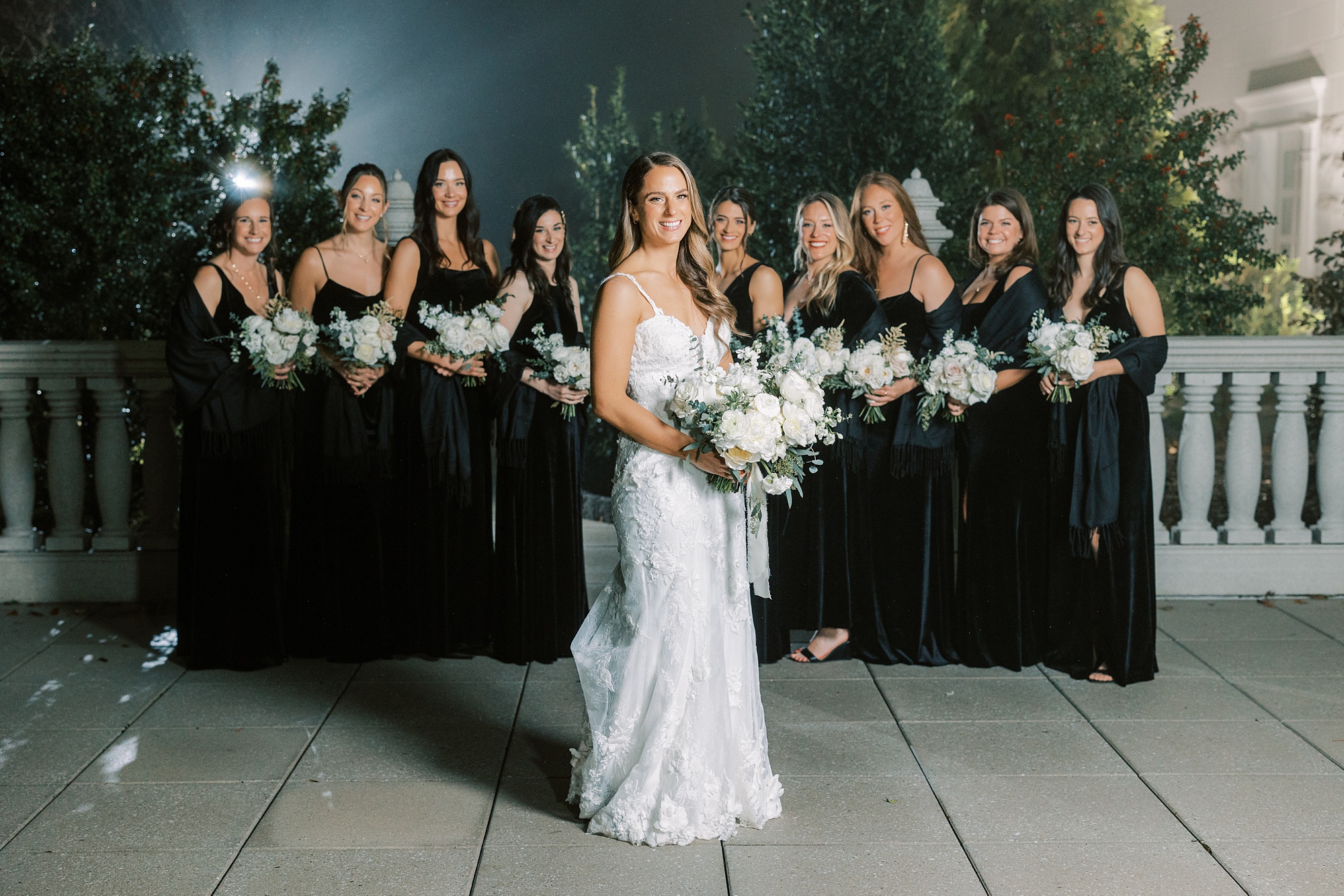bride poses in front of bridesmaids during portraits in New Jersey park