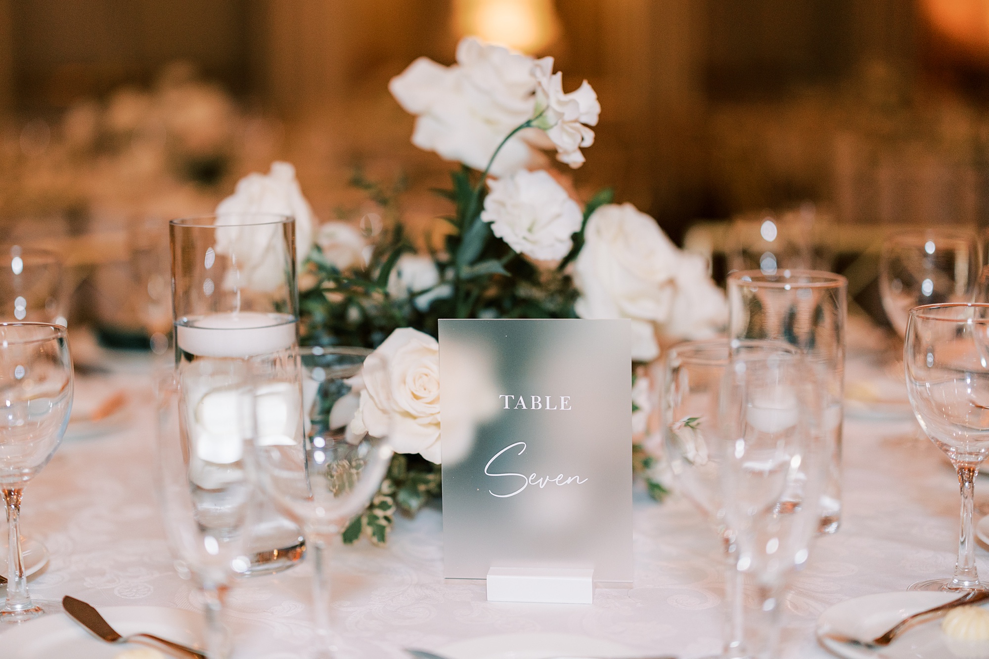 centerpieces with white flowers and acrylic table number signs