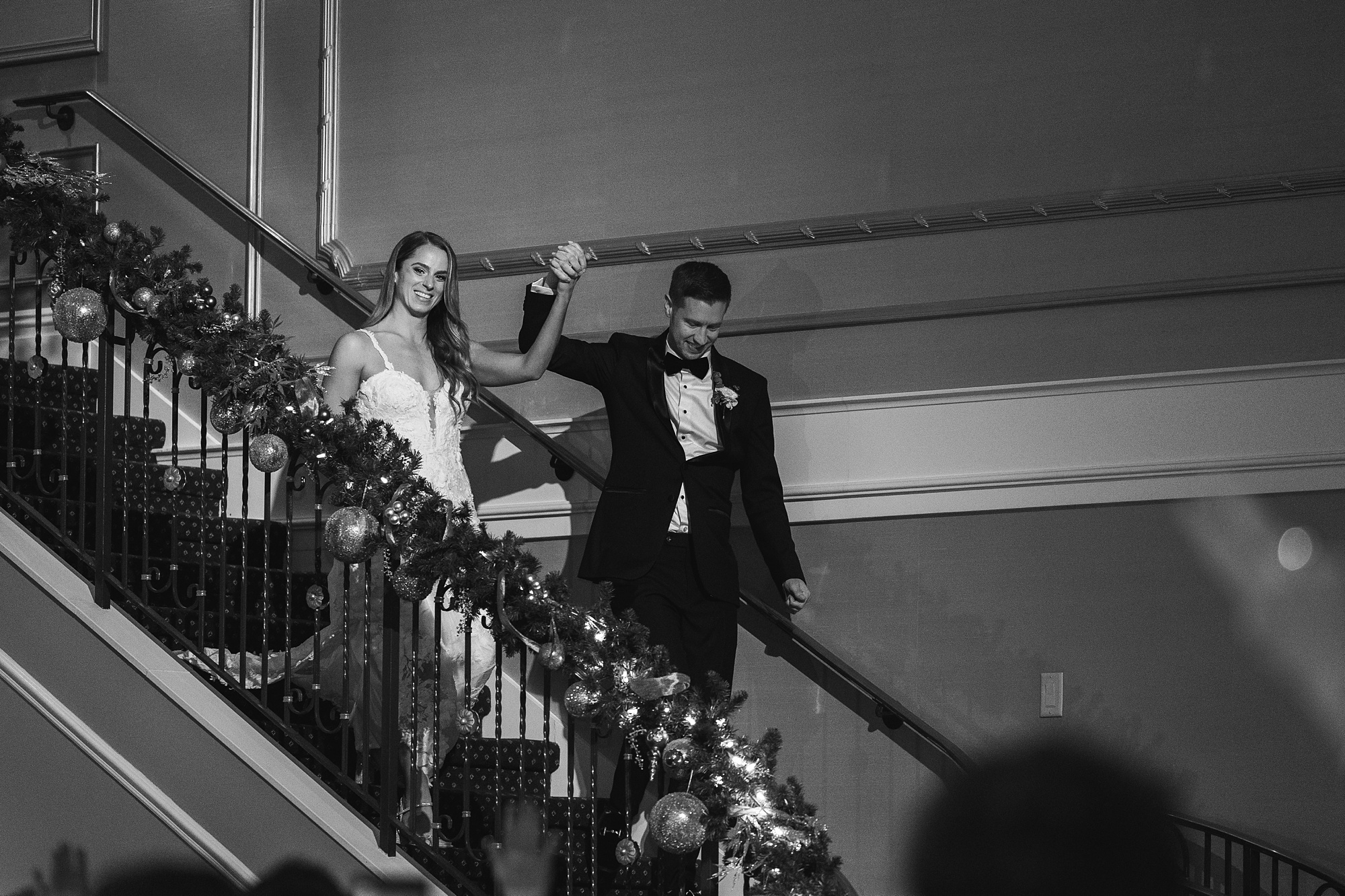groom helps bride down staircase inside The Palace at Somerset Park