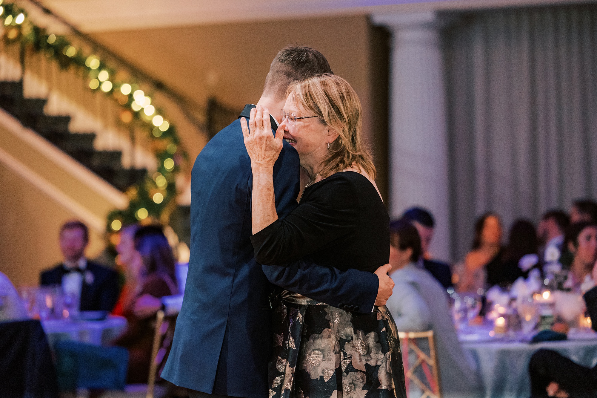 mother of groom hugs and cries into his shoulder during dances