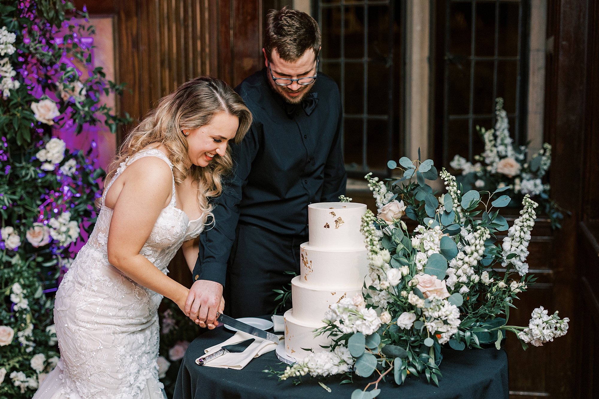 bride and groom cut wedding cake during Parque Ridley Creek wedding reception 