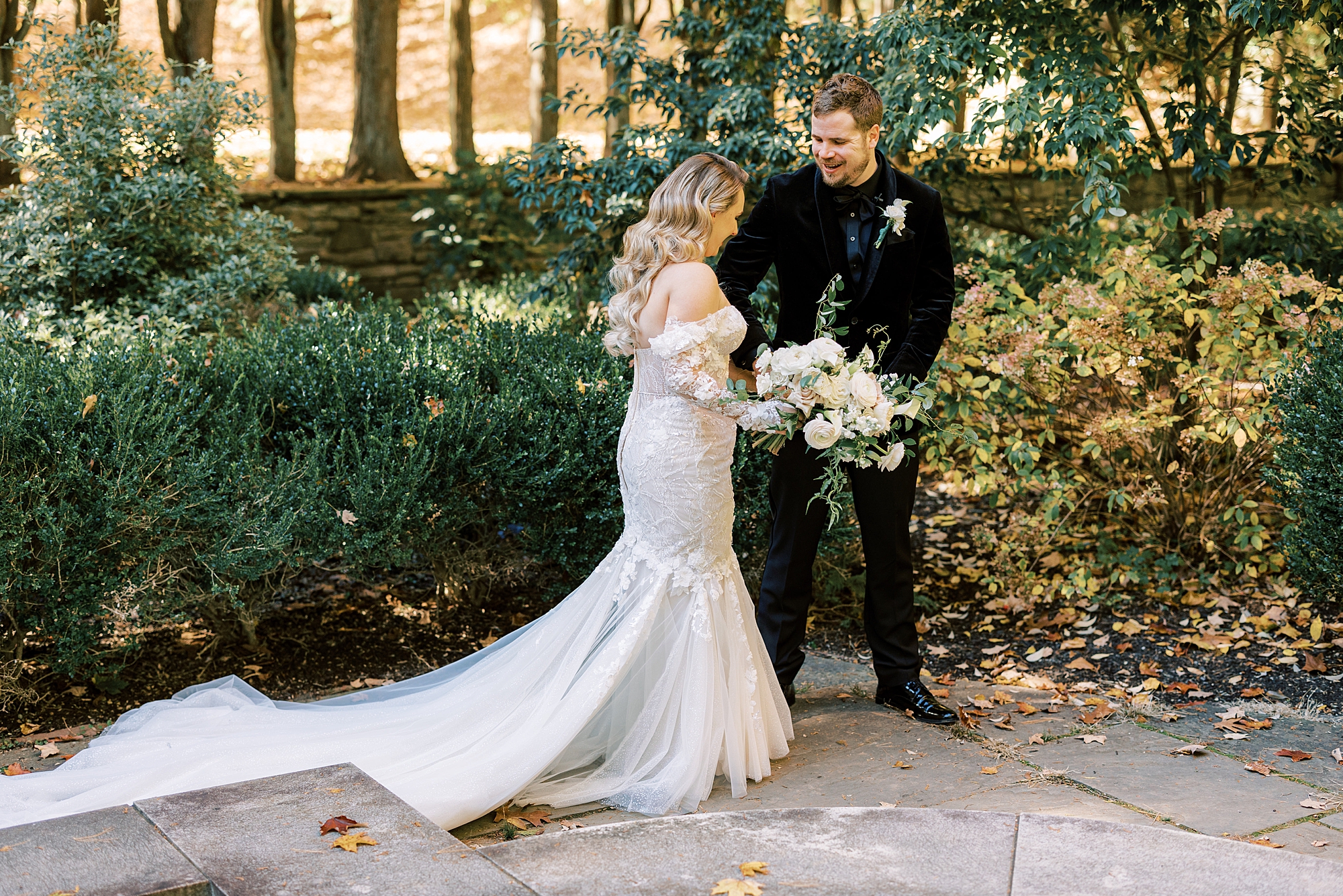 bride and groom look at each other's attire during fall wedding day first look 