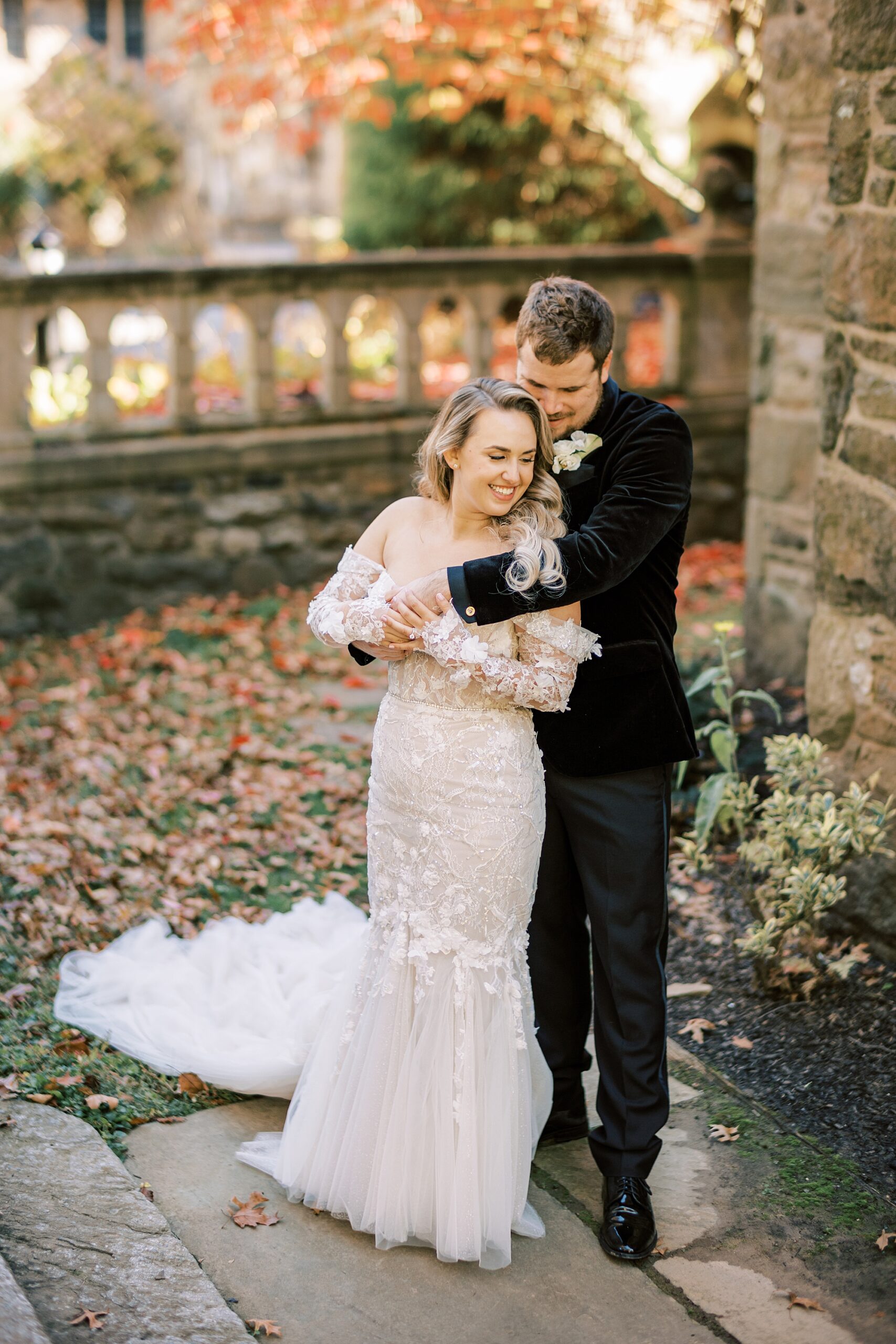 groom hugs bride from behind during fall wedding day