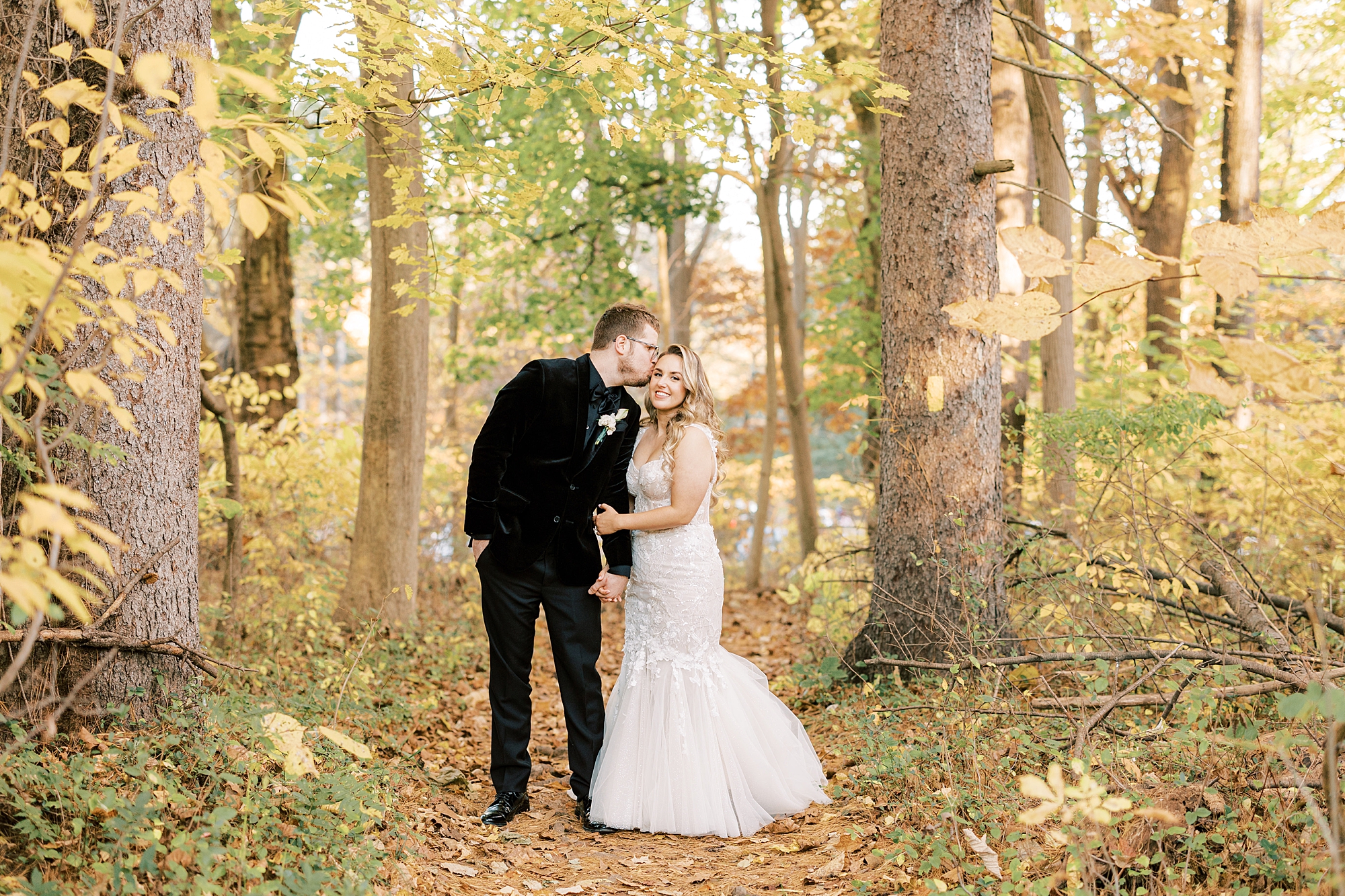 bride leans up to kiss groom in woods at Parque Ridley Creek