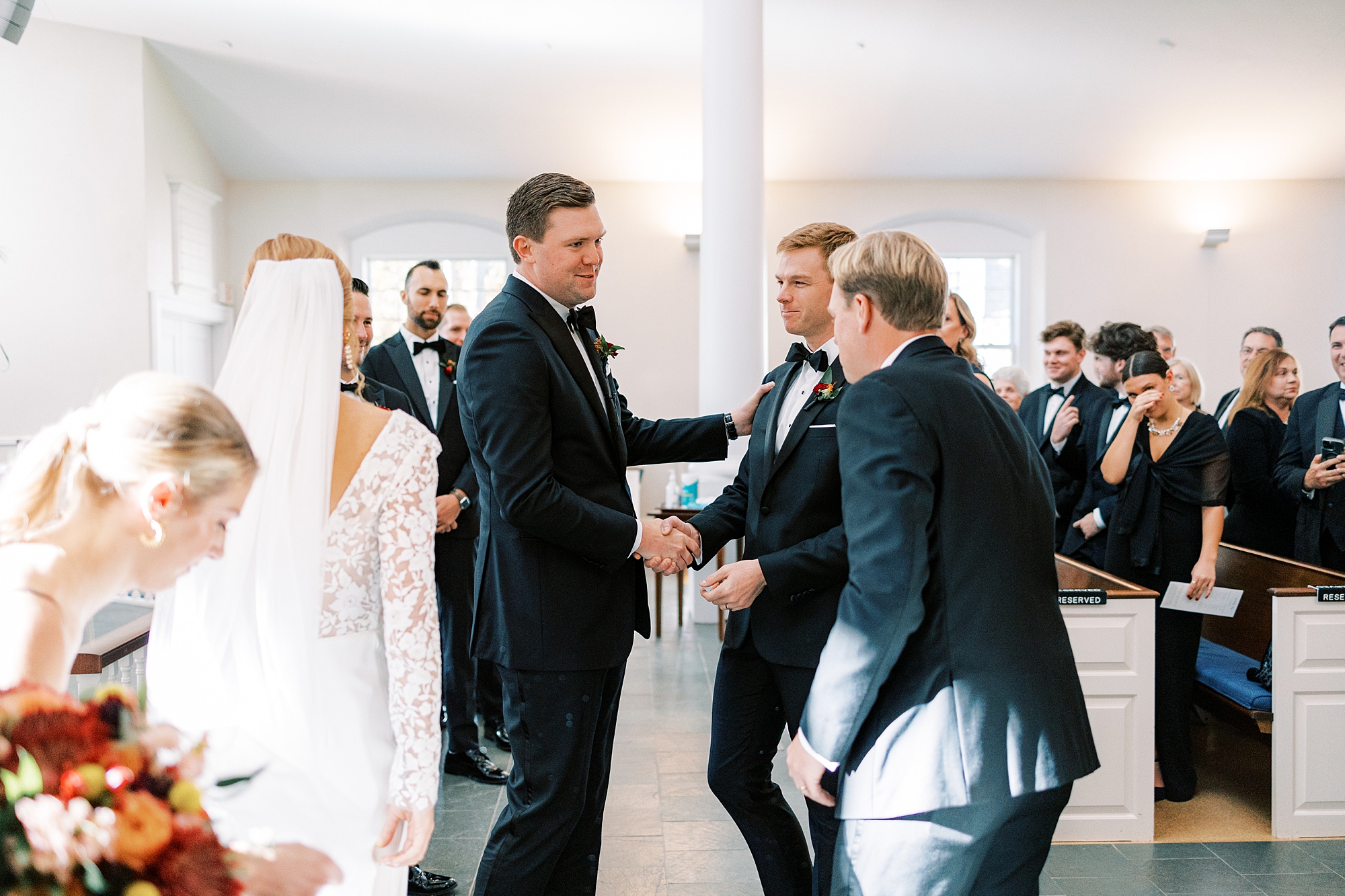 groom shakes hand with bride's brothers inside St. David’s Episcopal Church 