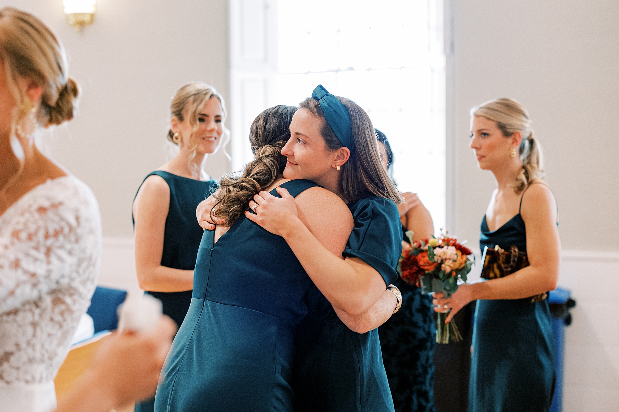 bridesmaids hug after wedding ceremony inside St. David’s Episcopal Church 