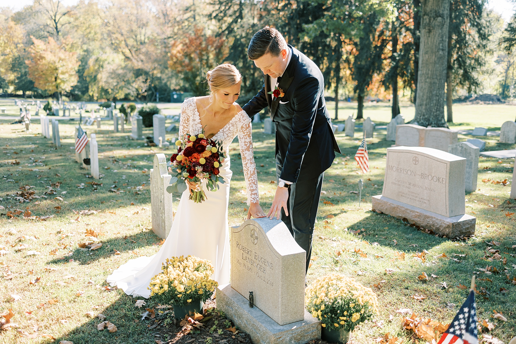 bride and groom reach to touch bride's father's headstone 