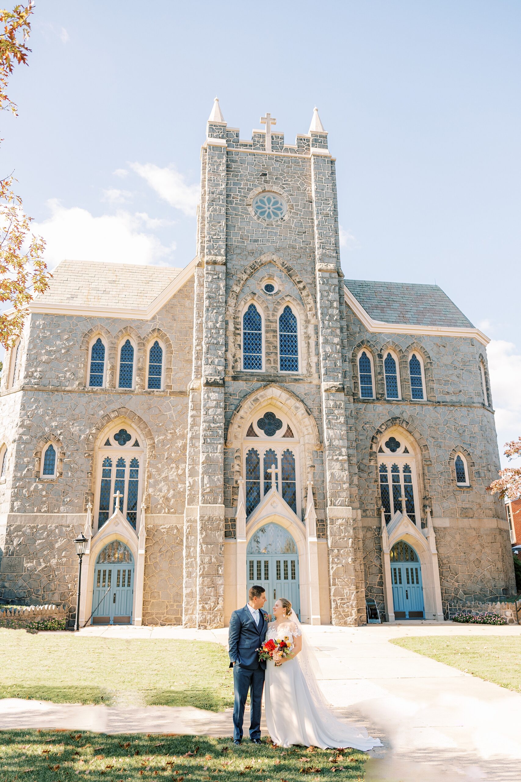 bride and groom kiss in front of  St. Ann’s Roman Catholic Church