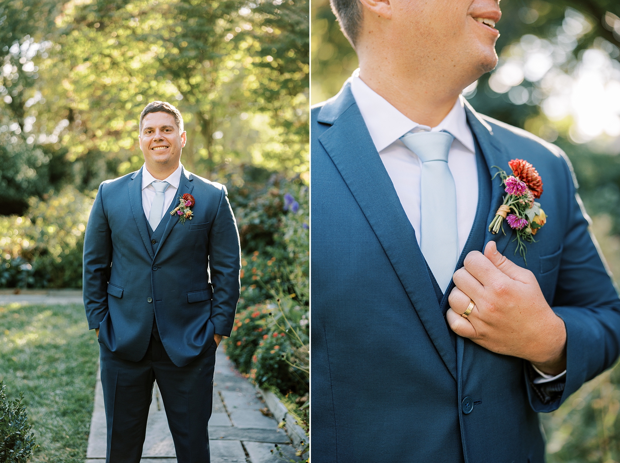groom stands in blue suit holding lapel under pink flowers 