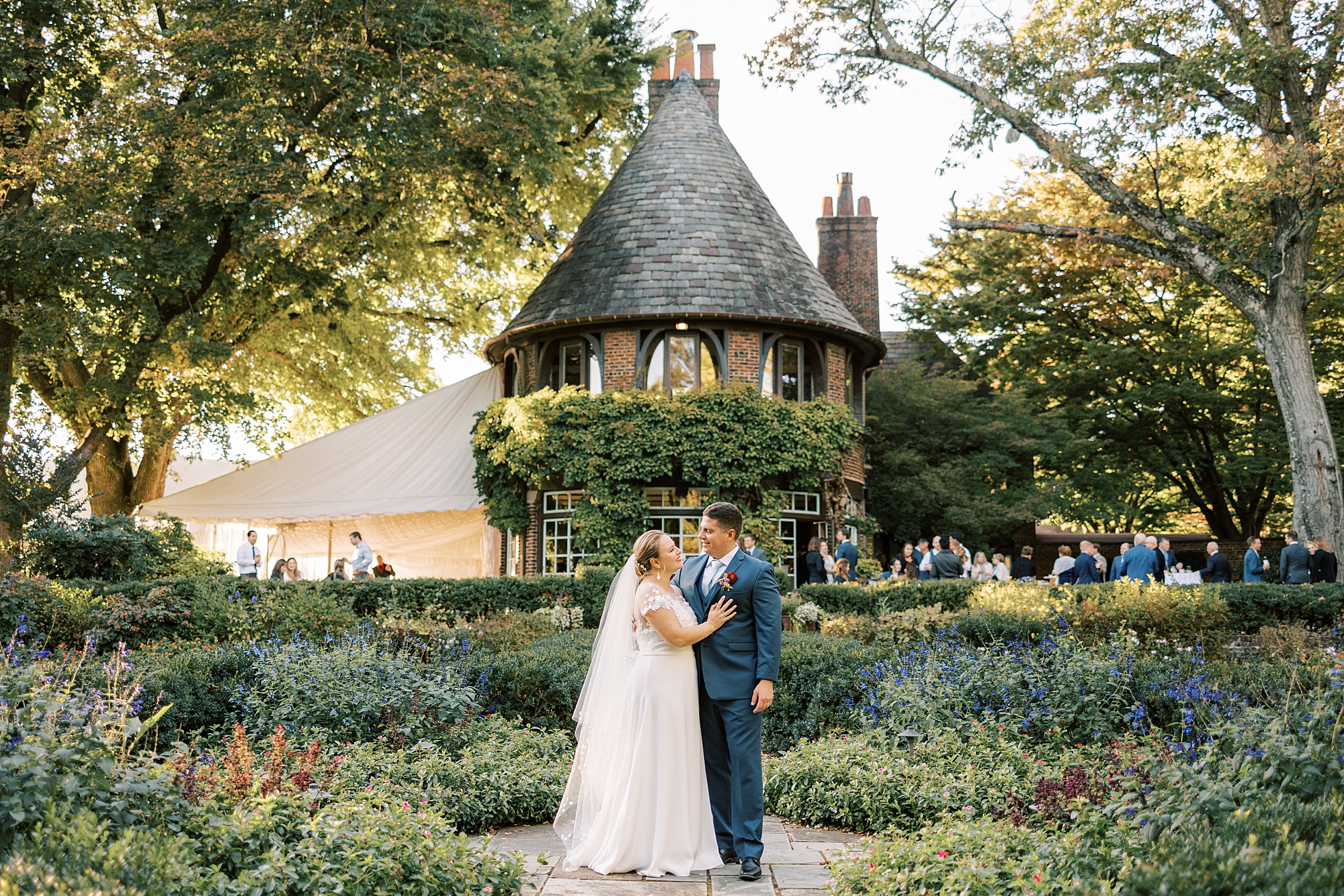 newlyweds look at each other in front of turrets at Greenville Country Club
