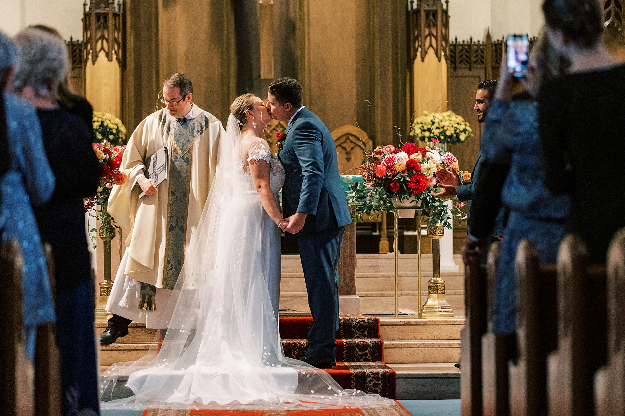 newlyweds kiss near pulpit at St. Ann’s Roman Catholic Church
