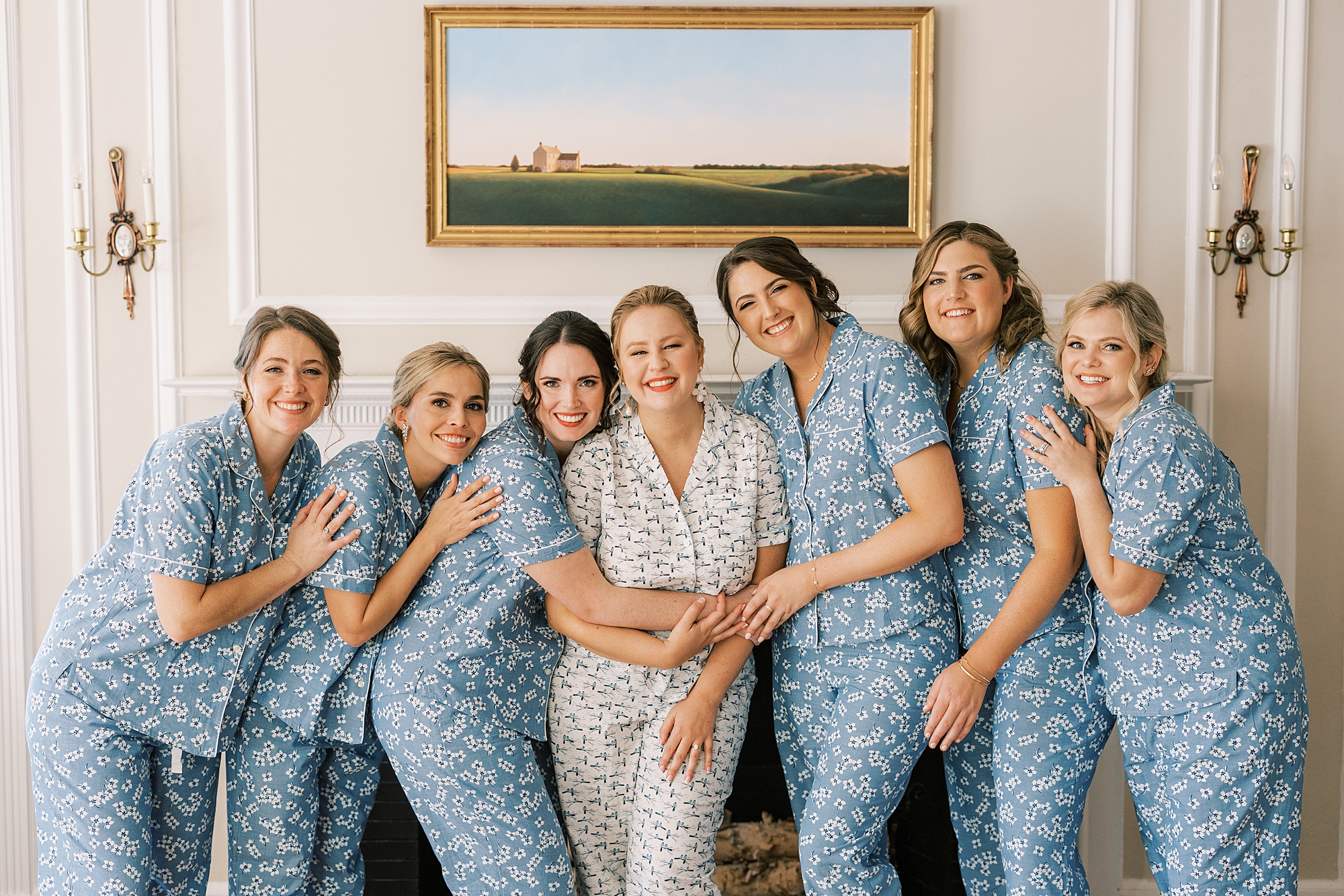 bride poses with bridesmaids in matching blue pajamas 